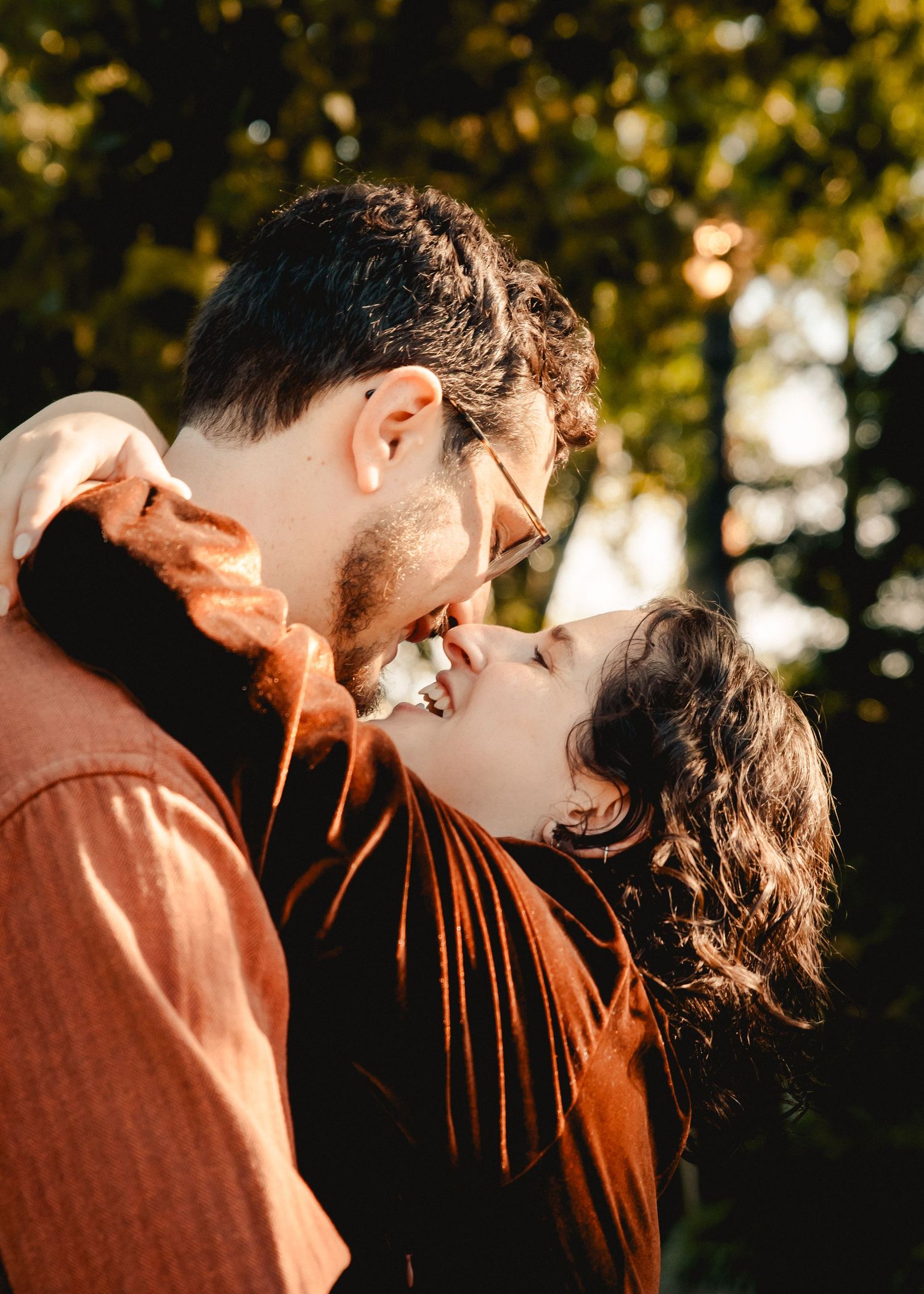 A couple smiling at each other while the woman's arms are around her fiance's neck taken in NYC.