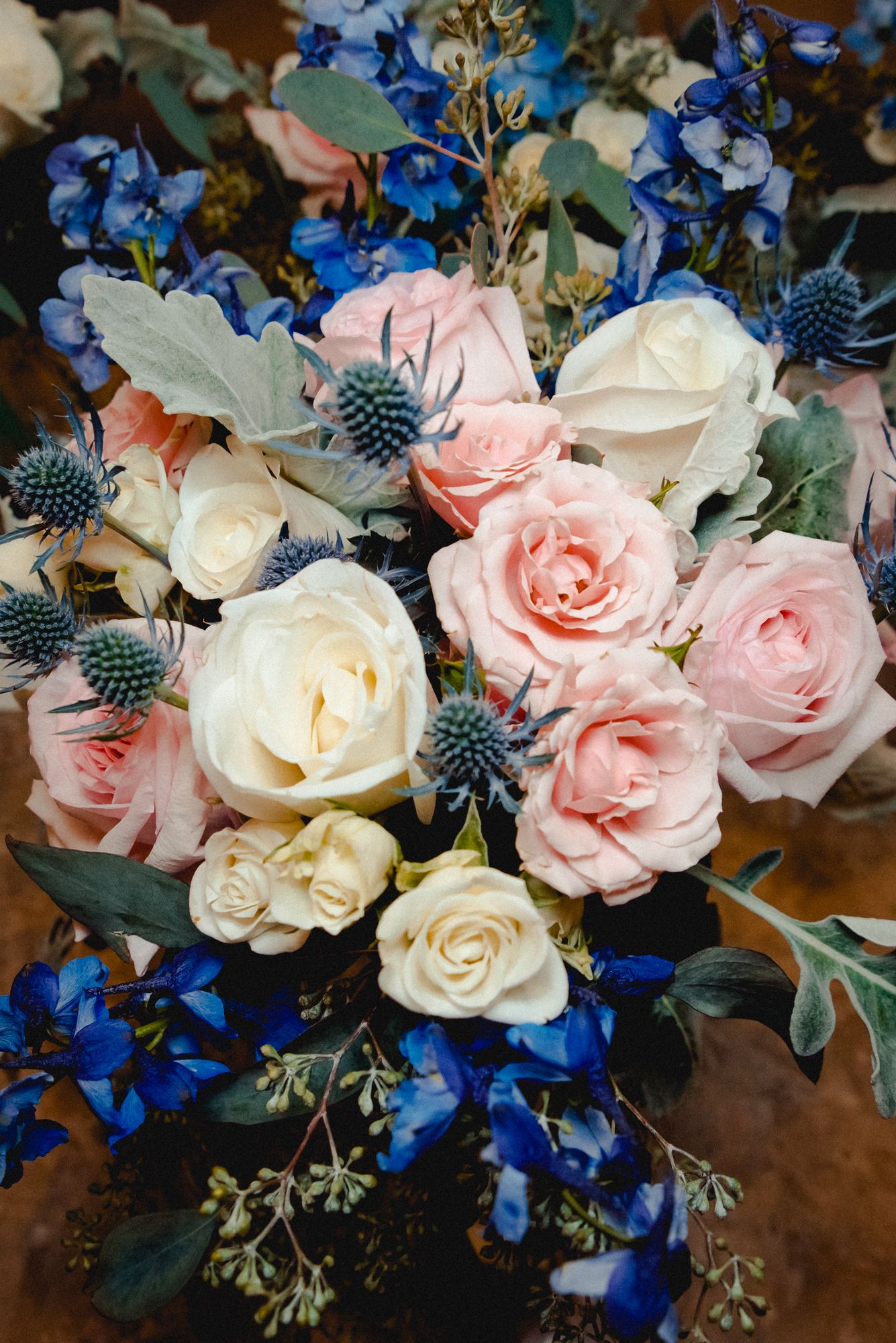 A gorgeous pink, white, and blue rose bouquet that serves as a centerpiece for the bride and groom at their Westchester, NY wedding.