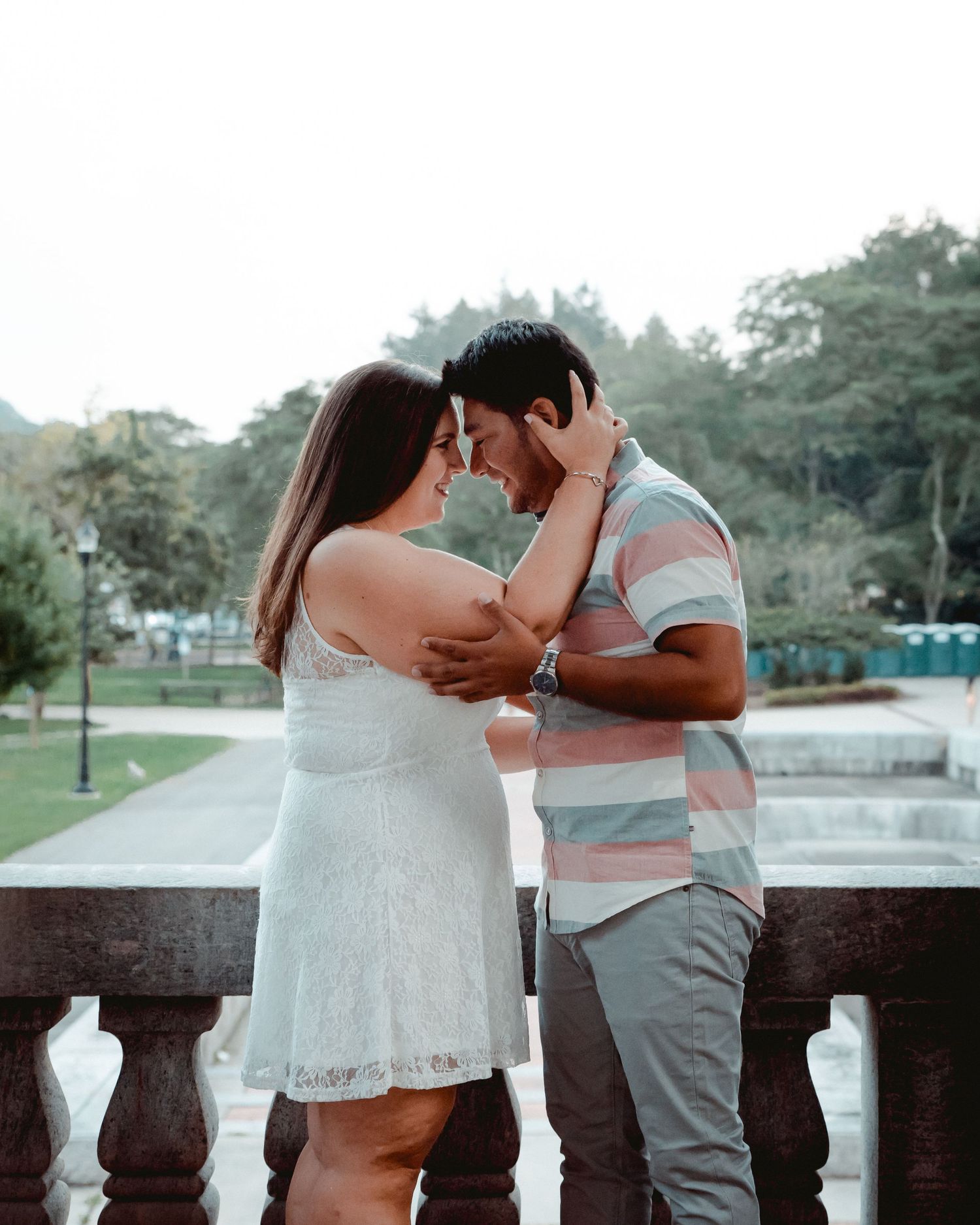 A newly engaged couple embrace warmly in Westchester, NY during their engagement session. The bride-to-be is caressing her fiance's face.