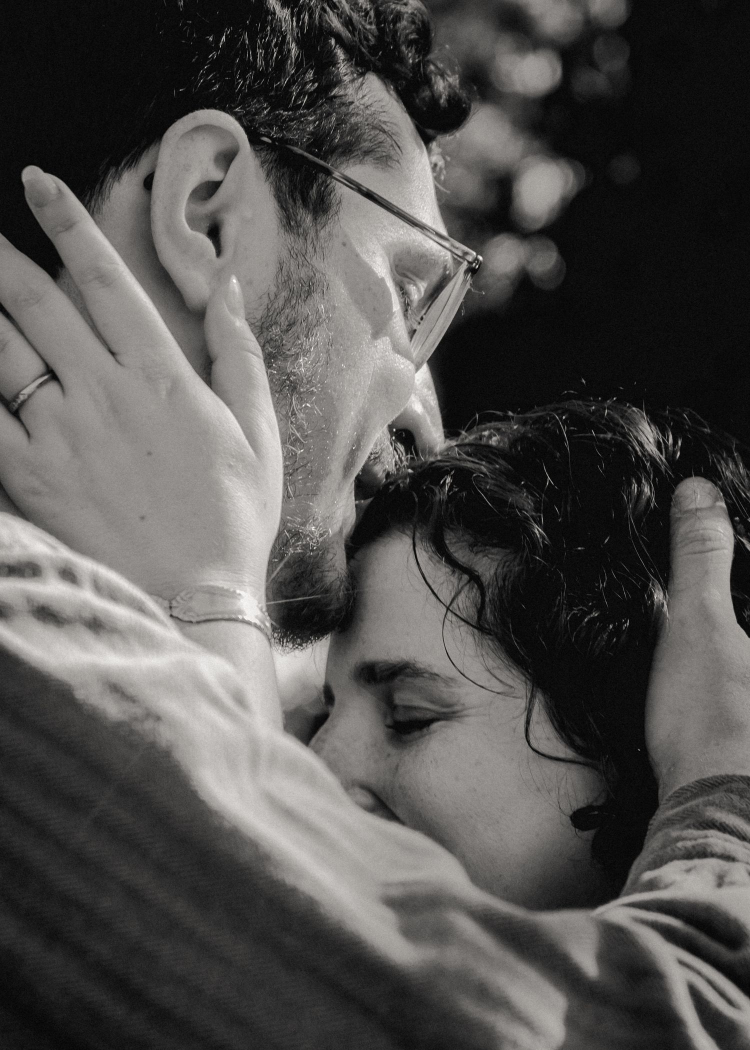 A close up of a man kissing his fiancee's forehead taken during their engagement photo session