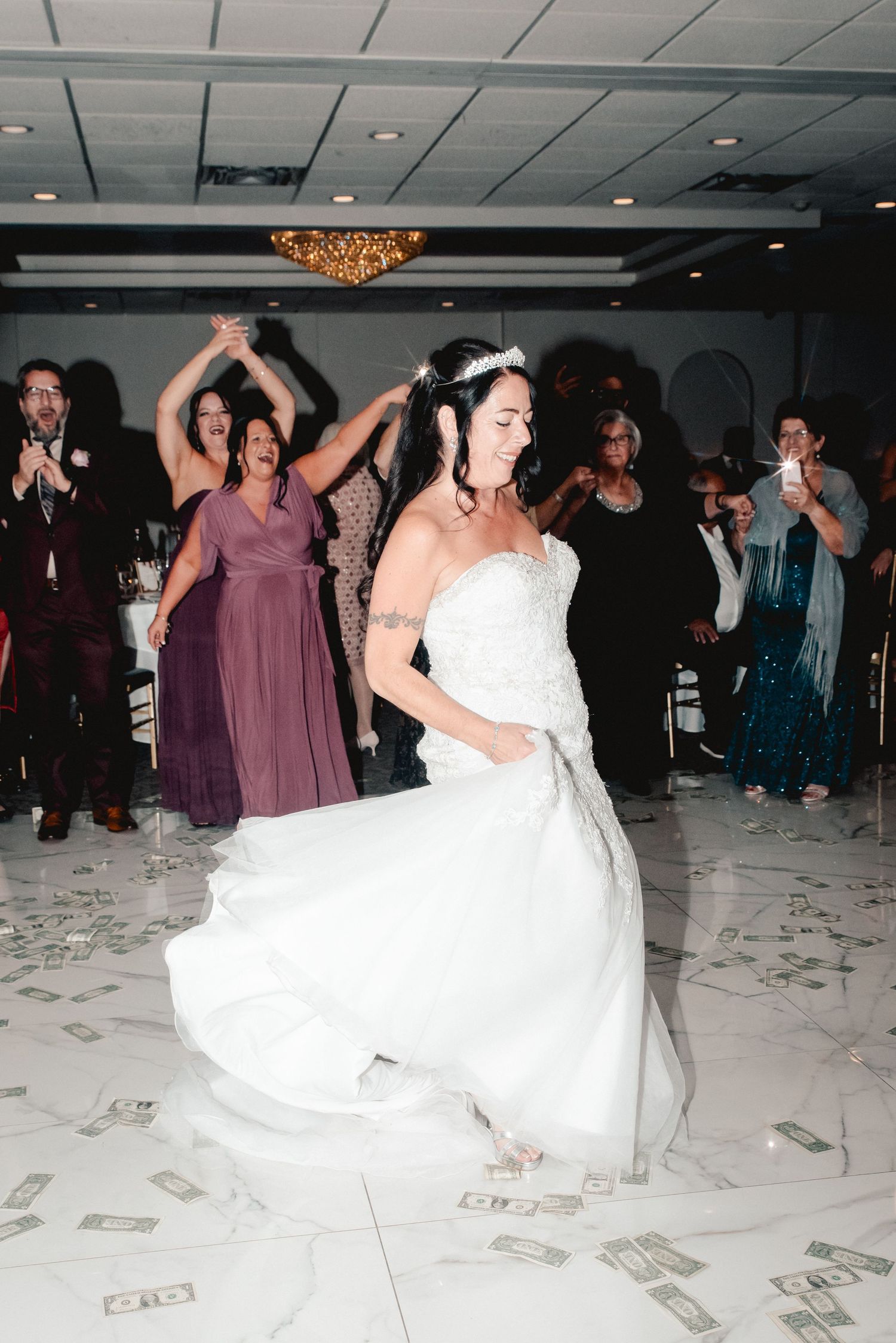 A candid photo bride dancing with her friends and family during wedding reception at the Riverdale in Endicott, NY.