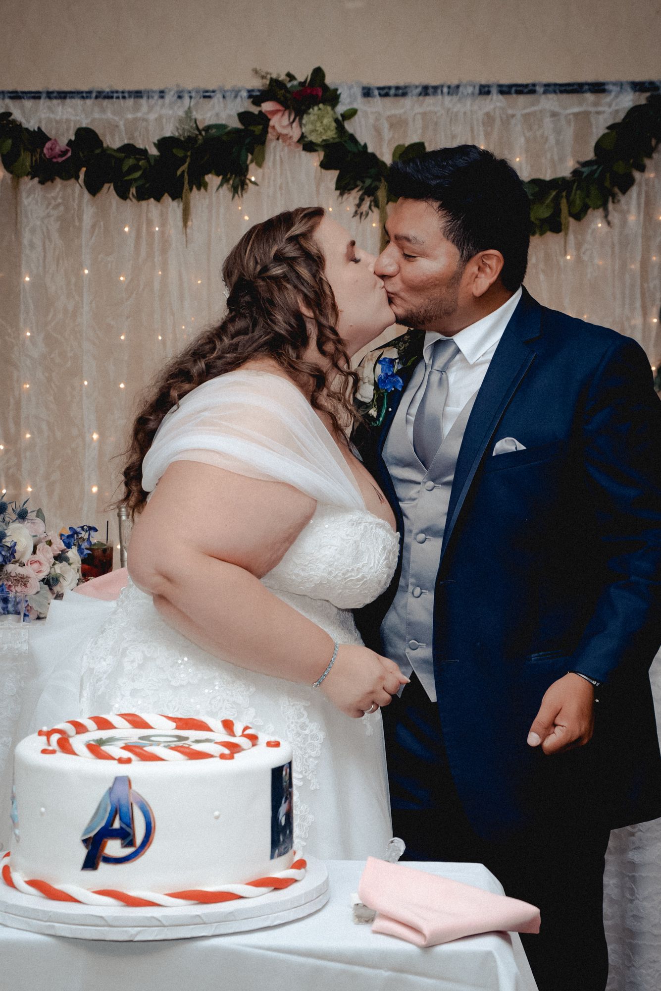 A celebratory kiss after the bride and groom cut their wedding cake at their wedding in Westchester, NY.
