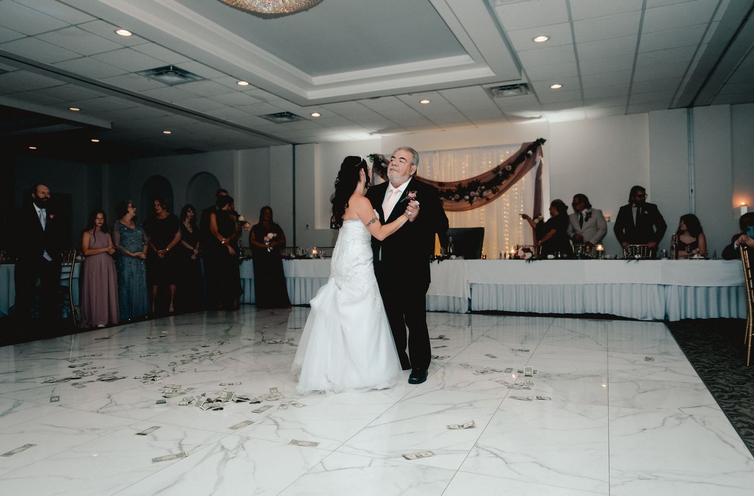 A father-daughter dance between the bride and her father at an Endicott, NY wedding. Family & friends gather to watch the heartwarming scene