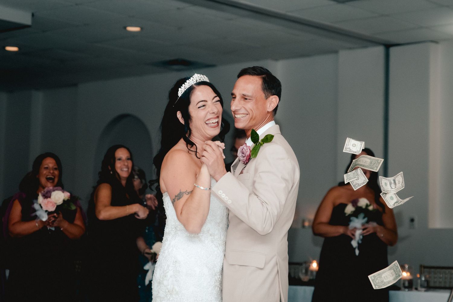 The bride and groom are smiling as they share their first dance as husband and wife at their wedding reception in Endicott, NY.