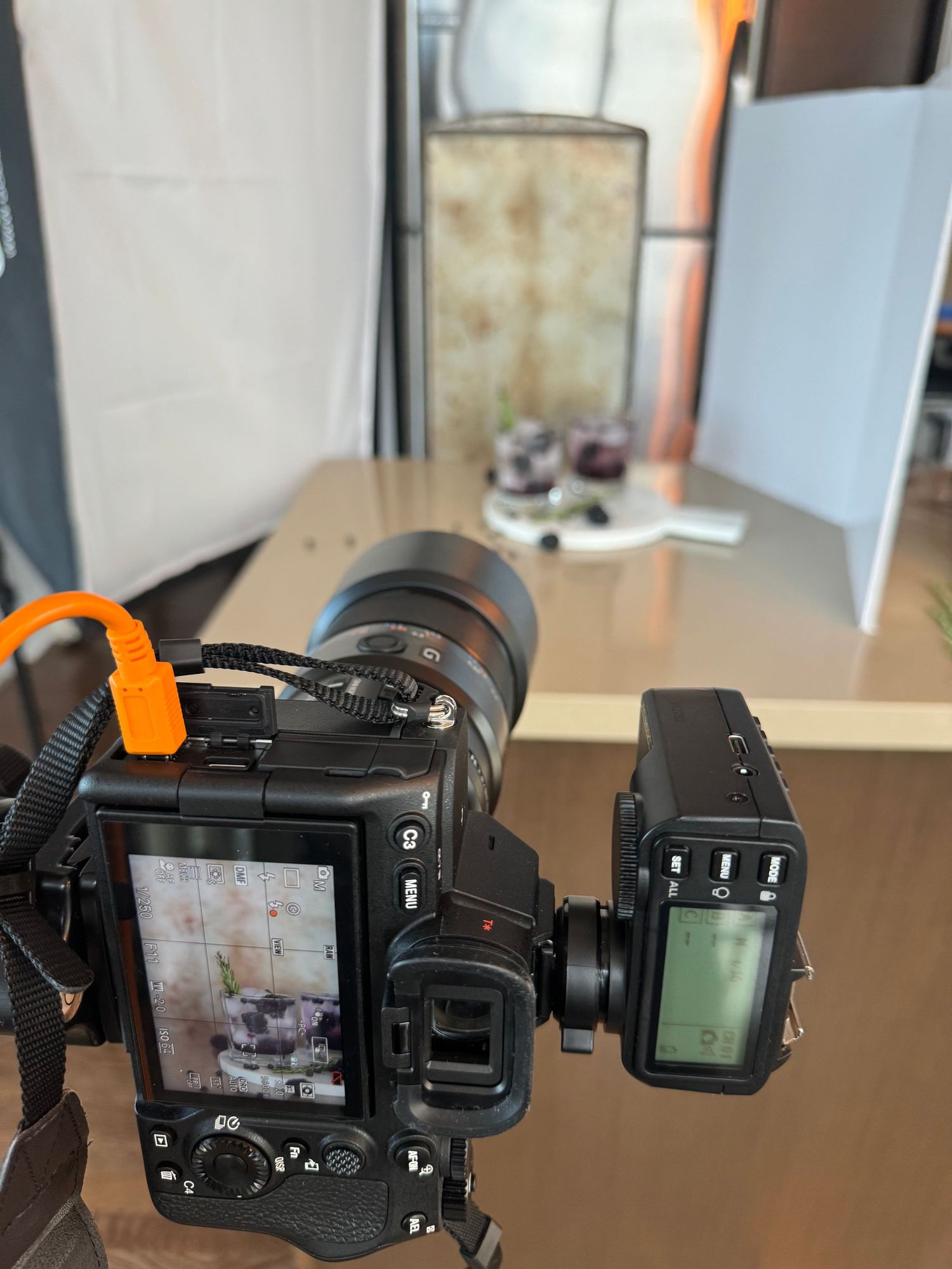 Behind the scenes of a moody light setup. I used one light in a rectangular soft box at the rear left. Bounced on the right to bring some more light to the front of the main glass. In post production I increased the contrast, deepened the shadows, and desaturated the yellows and oranges. And yes that is an old sheet pan as a backdrop.
