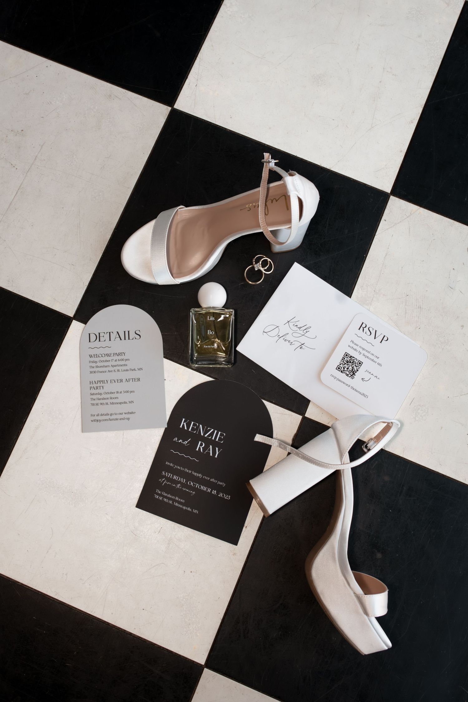 Wedding invitation suite with black and white cards, RSVP details, and elegant white high heel shoes on checkered floor. Minneapolis, MN,