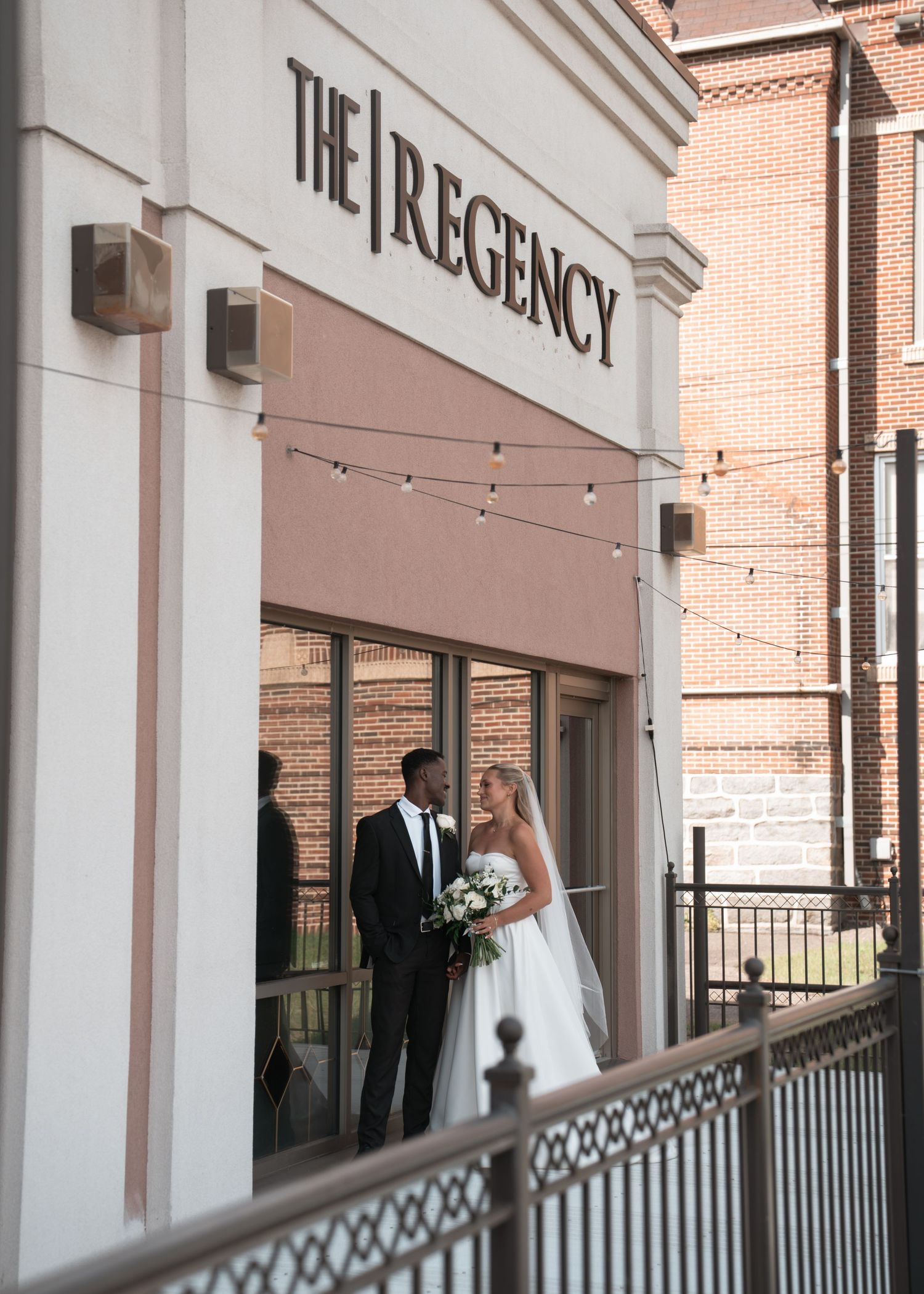 Wedding couple celebrating outside The Regency building entrance.