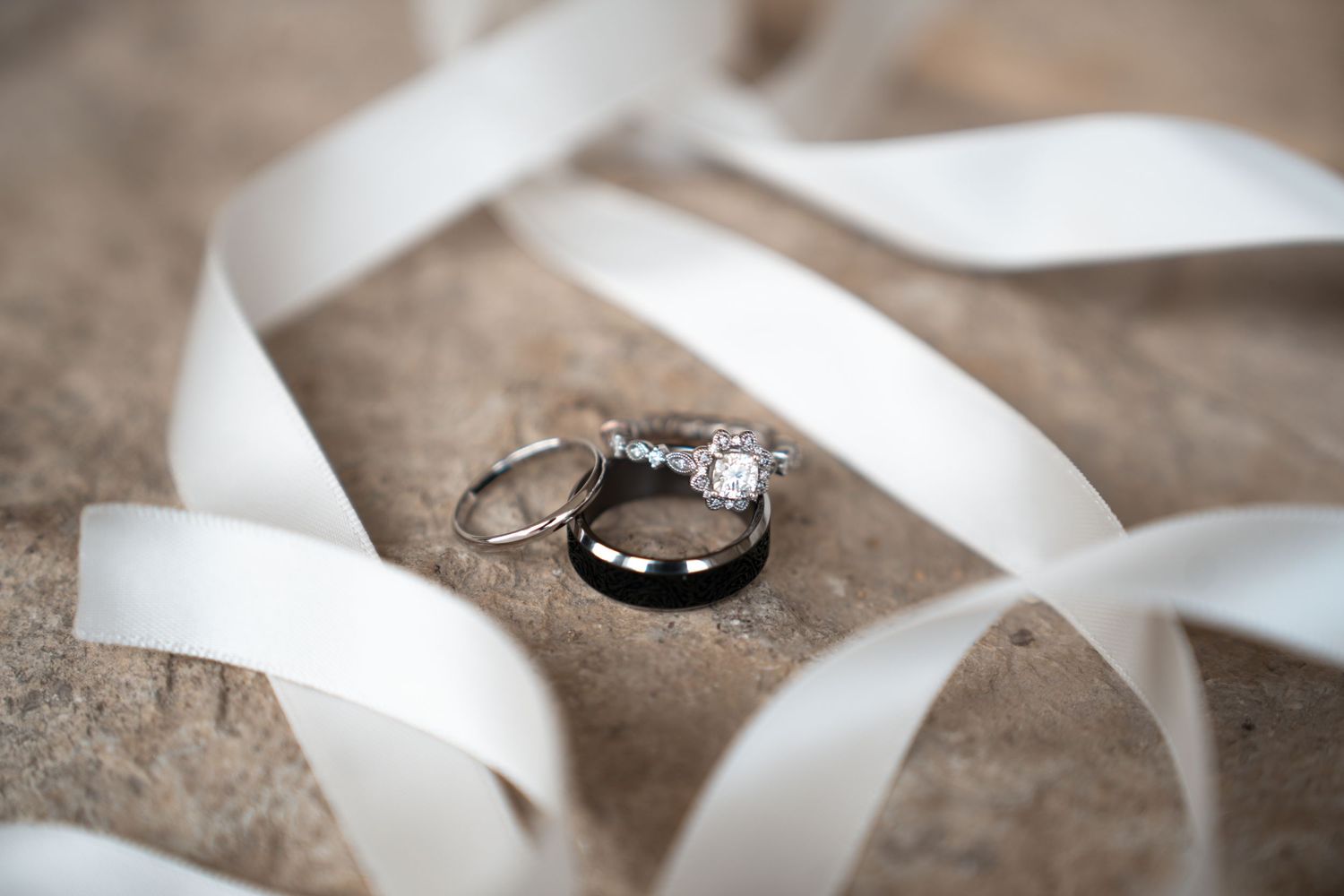 White satin ribbon curls and twists elegantly against a soft beige textured background. Mayowood Stonebarn in Rochester, Minnesota