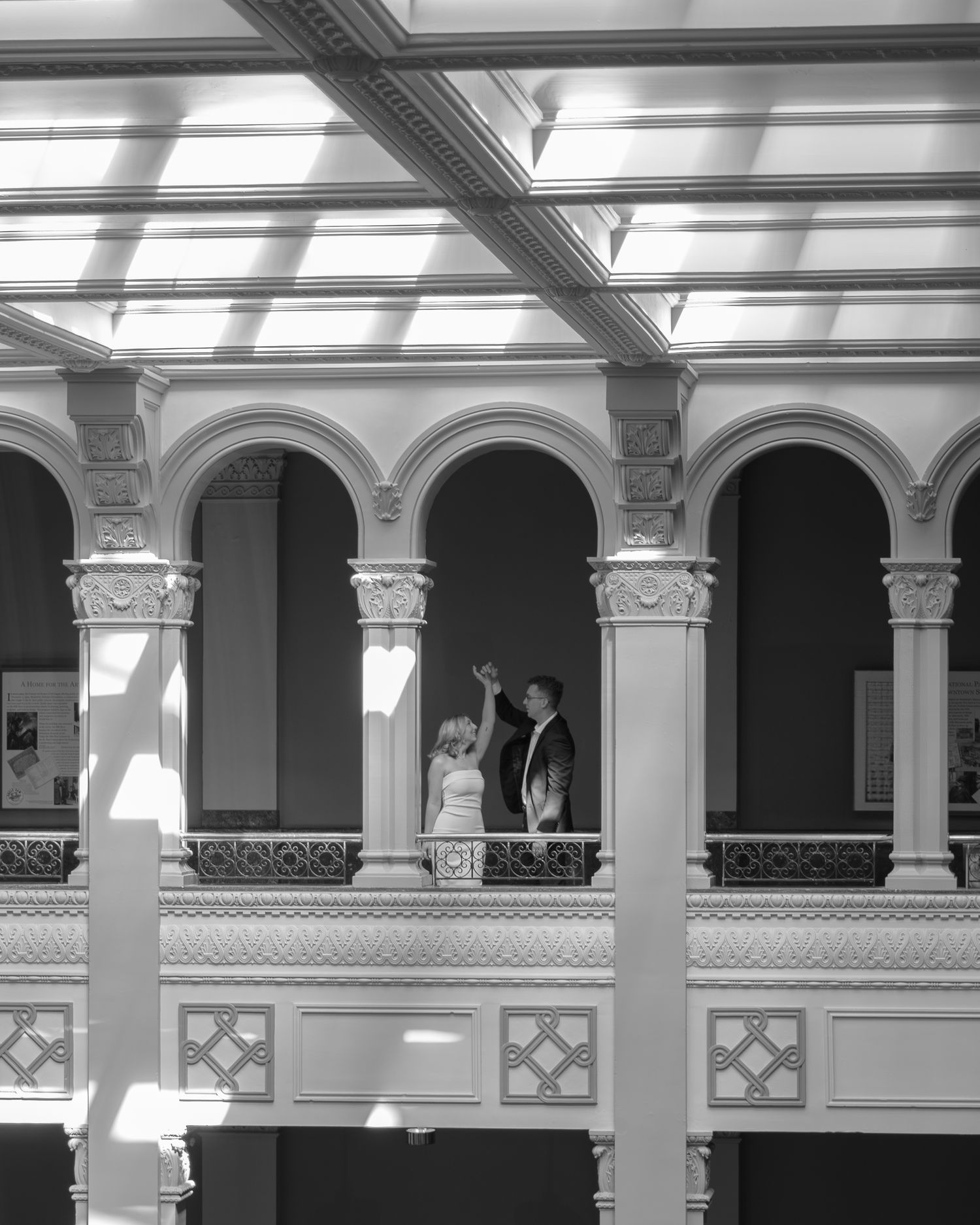 Architectural details of a classical colonnade with ornate columns and arches in black and white.