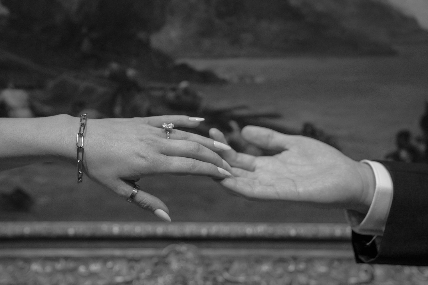 Black and white photo series showing hands reaching out in various poses against a dark background.