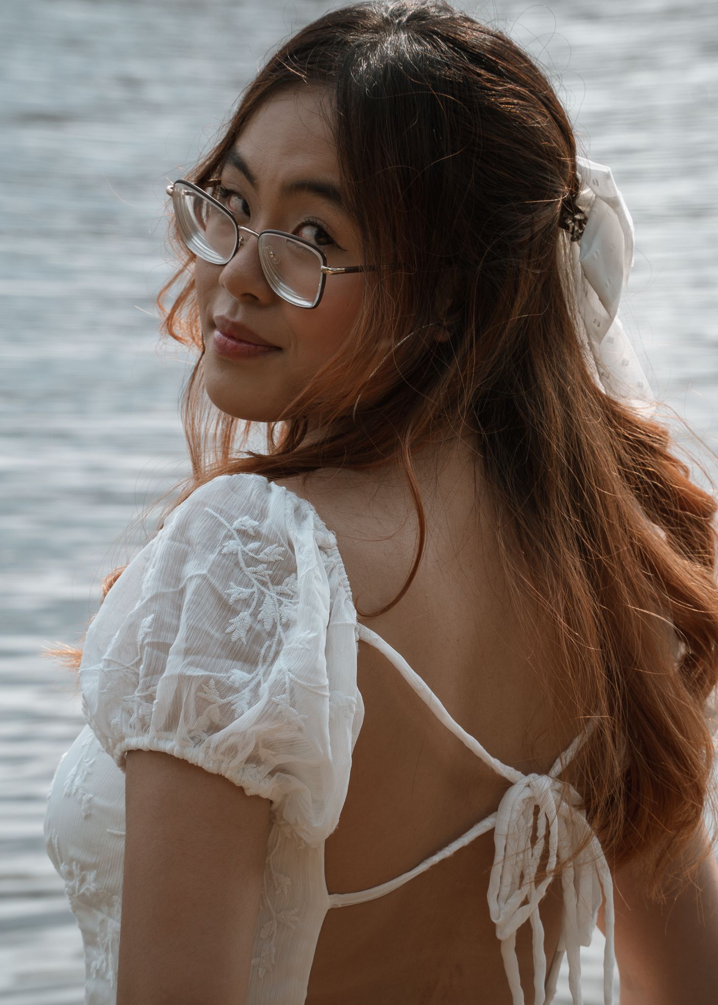 Portrait sequence in a white lace top against water background with natural lighting.
