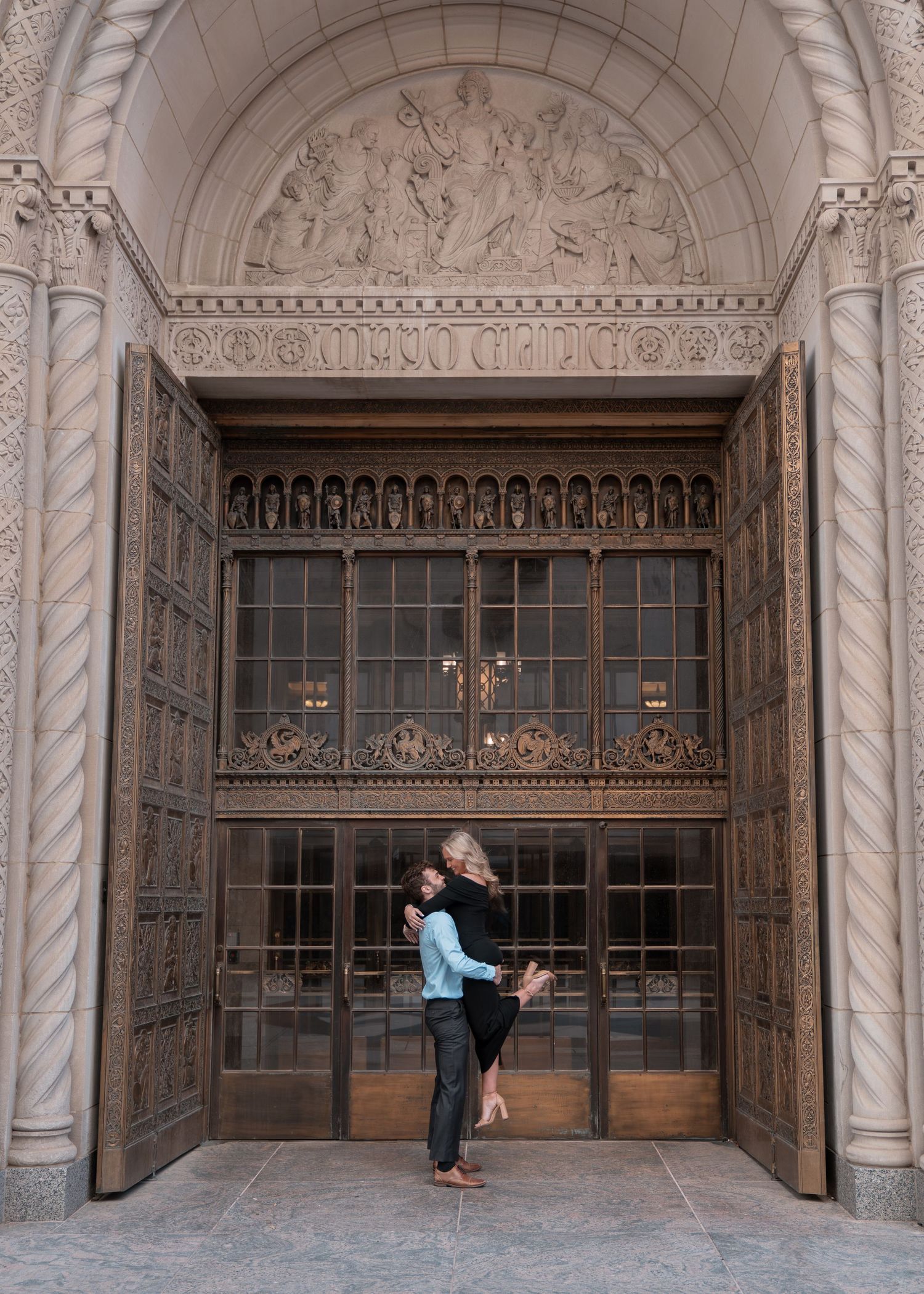 Ornate stone archway entrance with decorative carvings and glass doors.