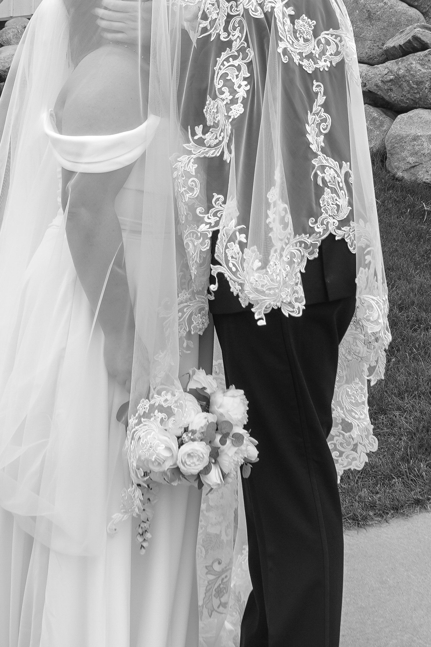 Close-up of intricate lace veil and wedding dress details with a bouquet.