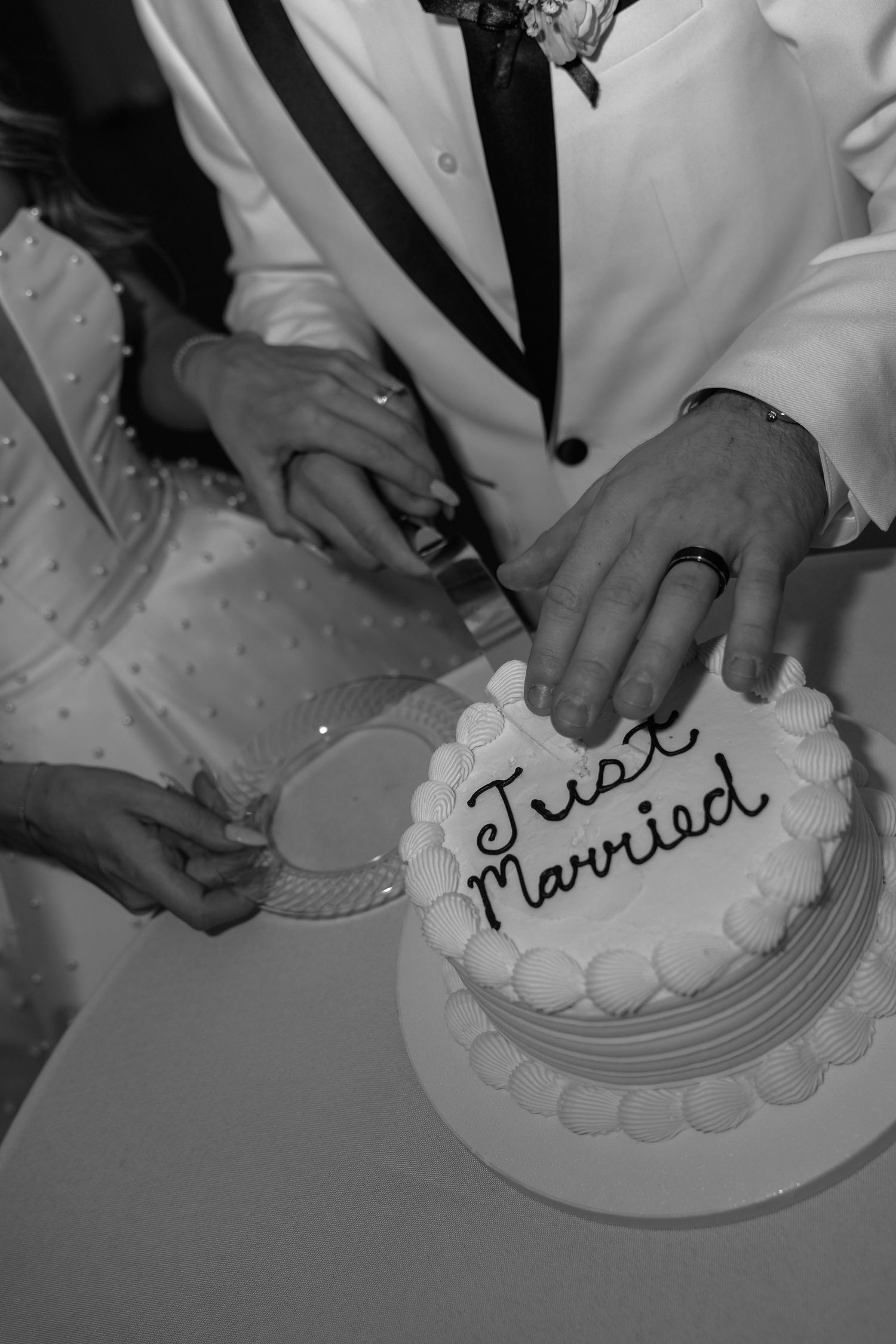 Black and white photo sequence showing hands cutting and serving a wedding cake at a reception celebration.