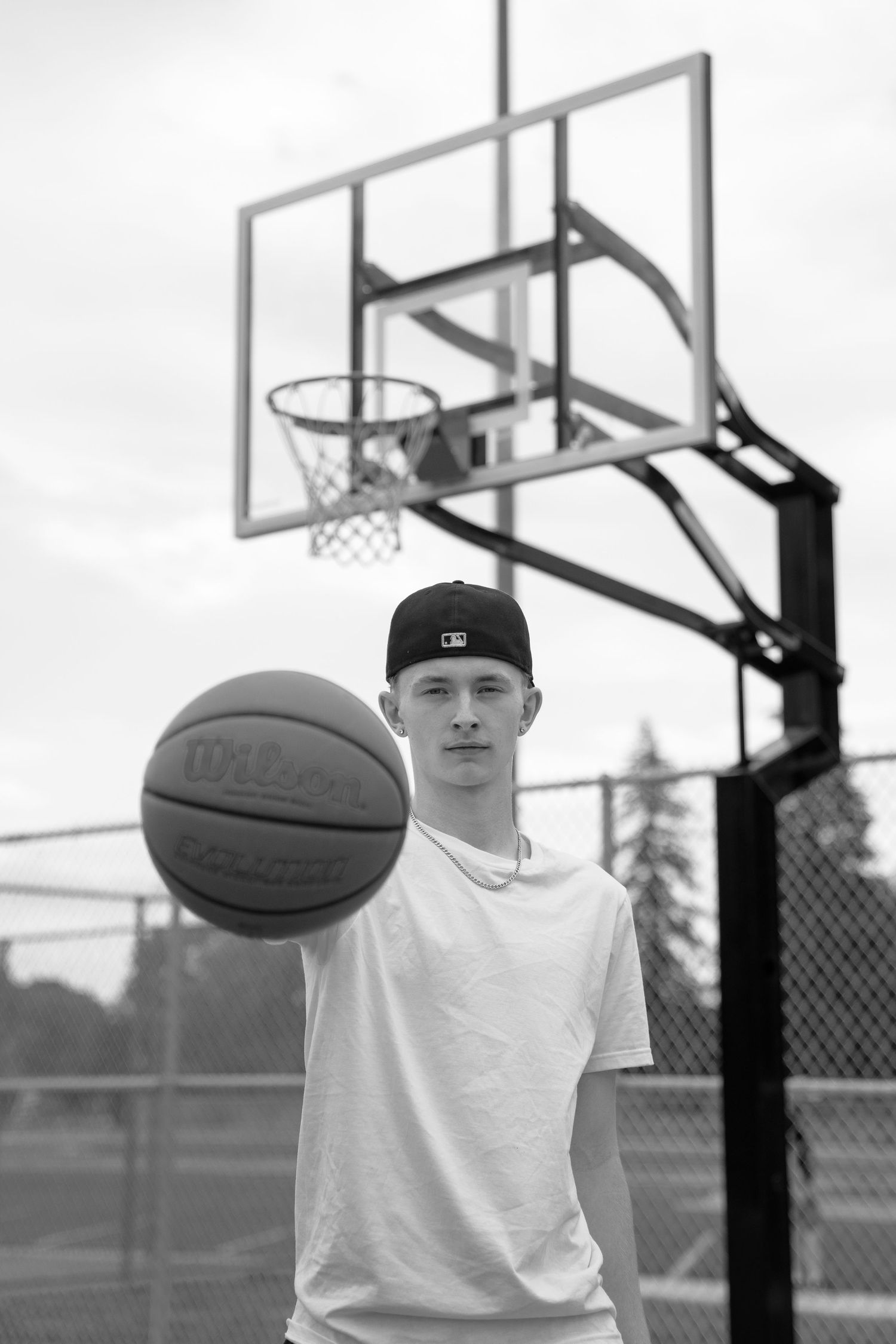 Basketball player in casual attire practicing ball handling skills on court.
