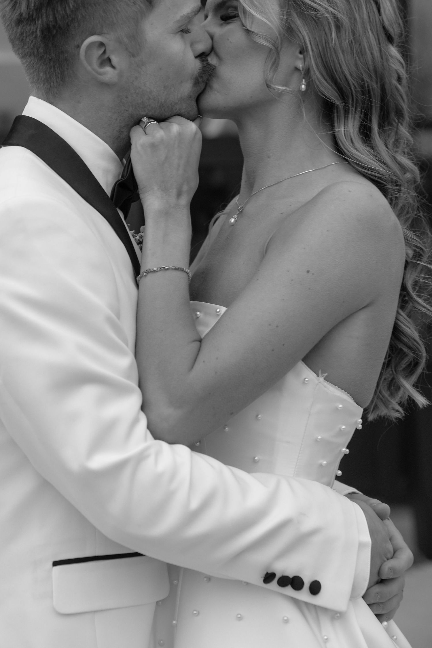 A romantic series of black and white wedding photos showing a couple sharing tender kisses in formal attire. White and Sable wedding venue