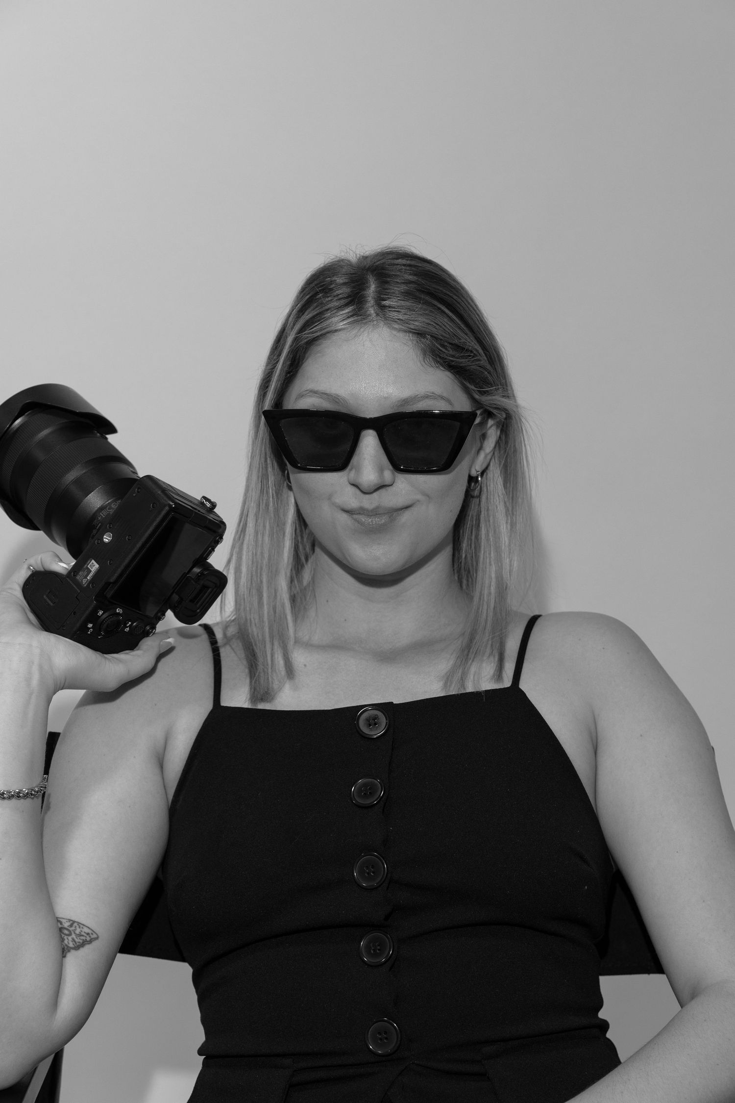 A series of four photos shows someone in a black top with buttons posing playfully with a camera.