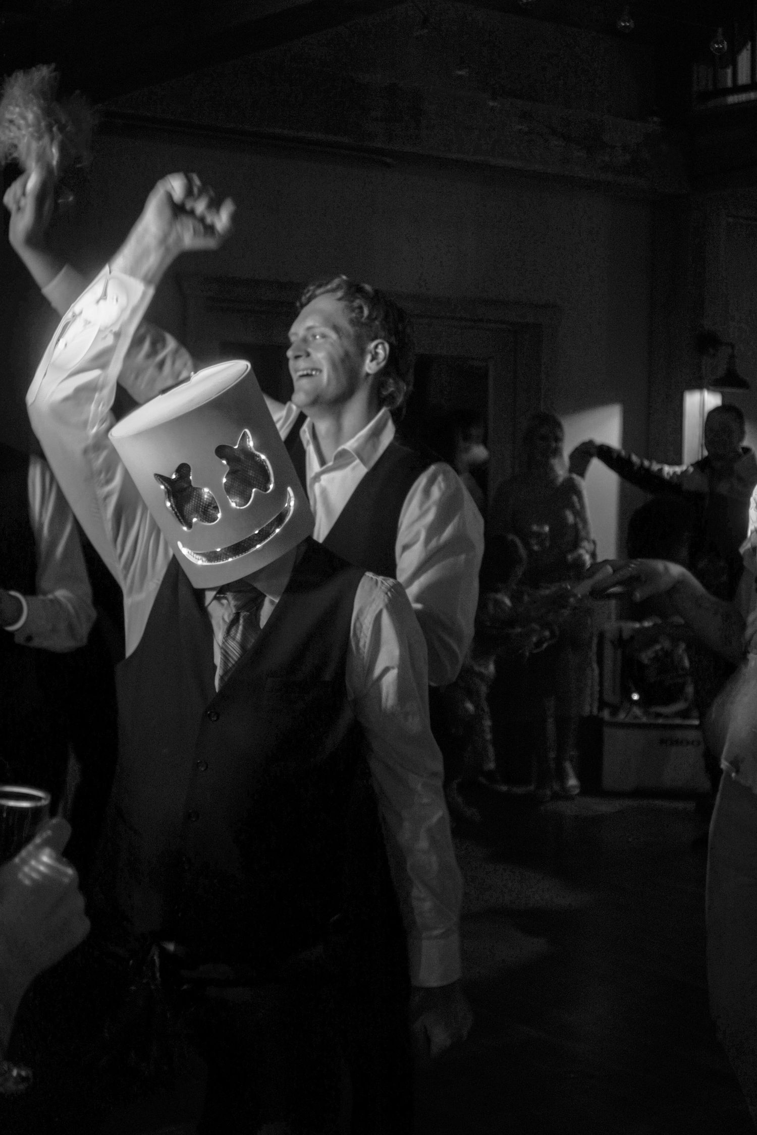 A couple dances together at a wedding reception, captured in a black and white photograph.