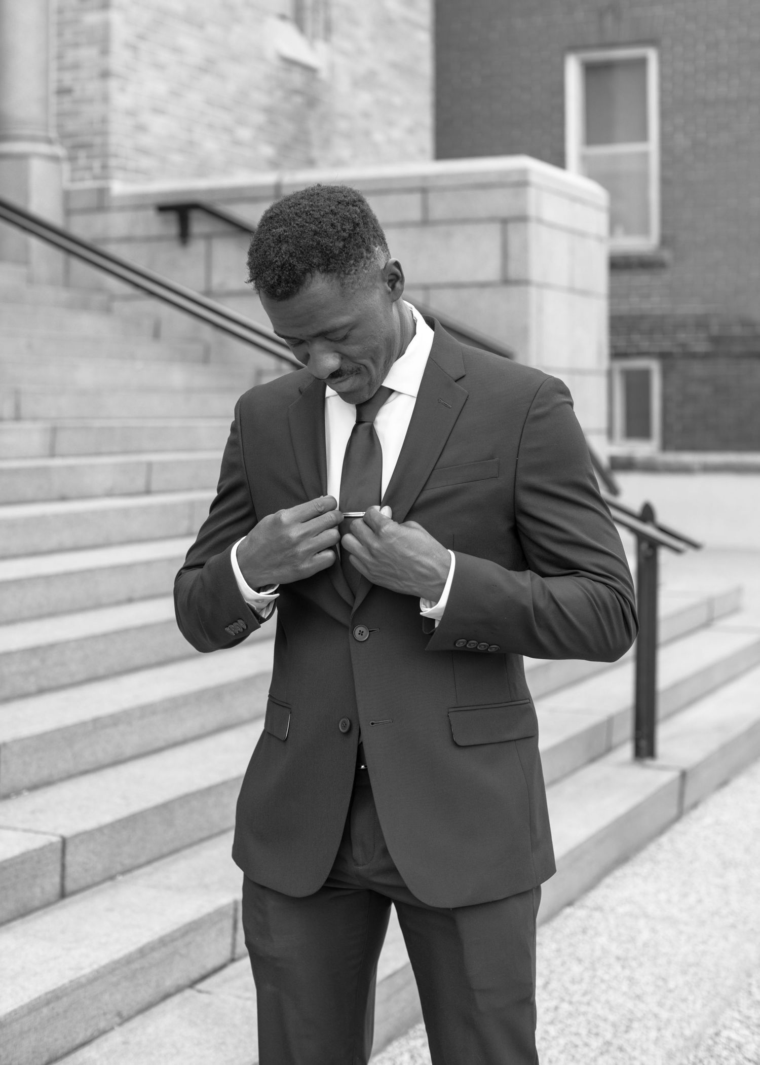 A series of black and white photos showing someone in a suit dabbing on stone steps.