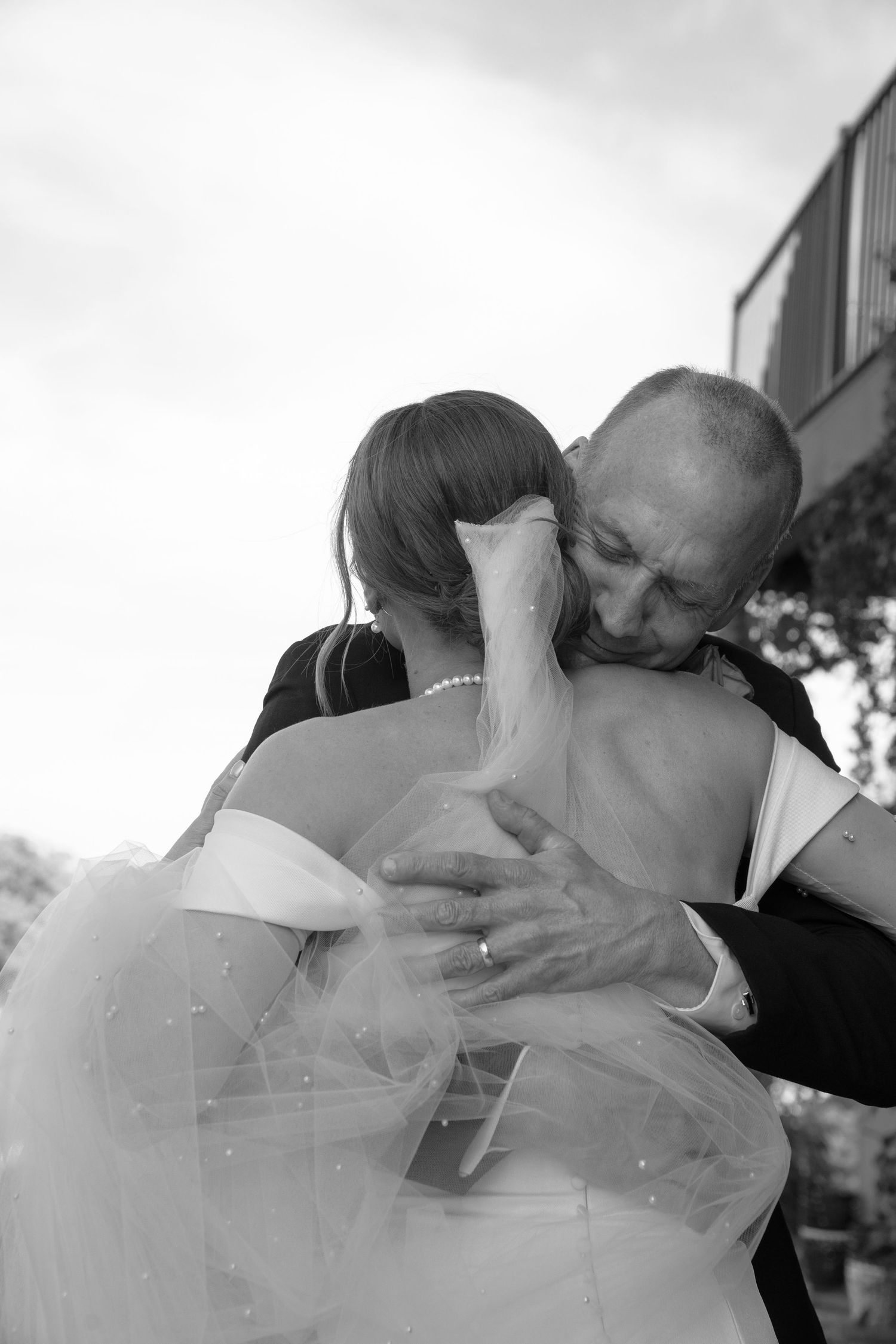 A heartwarming black and white photo showing the first look reaction between a bride and her father on wedding day.