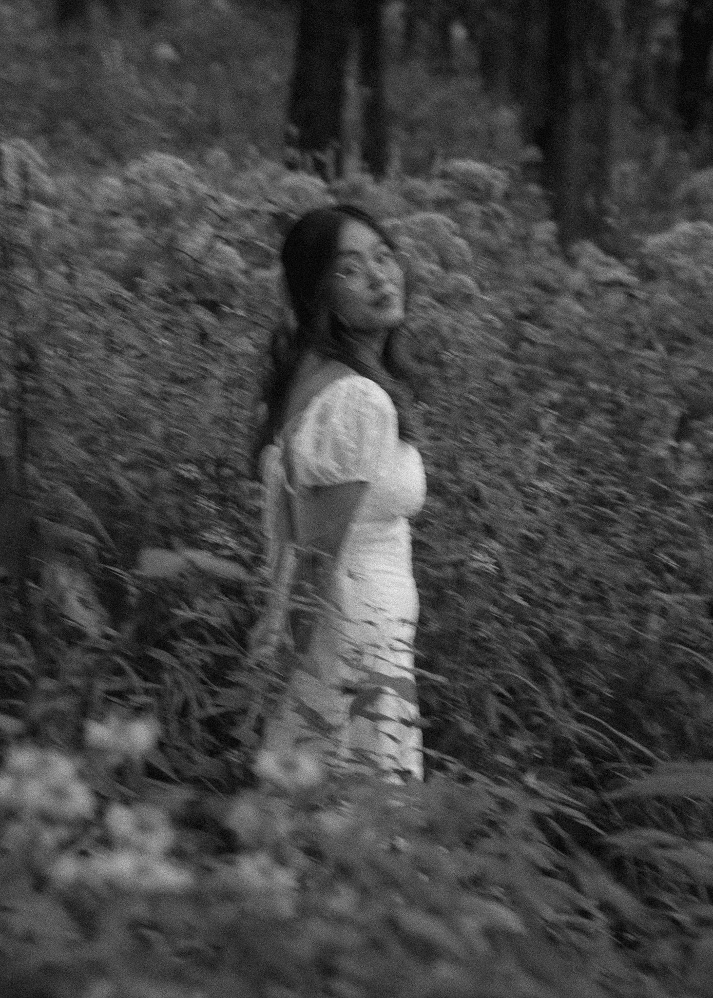 Black and white artistic portrait series in a natural outdoor setting with tall grass.