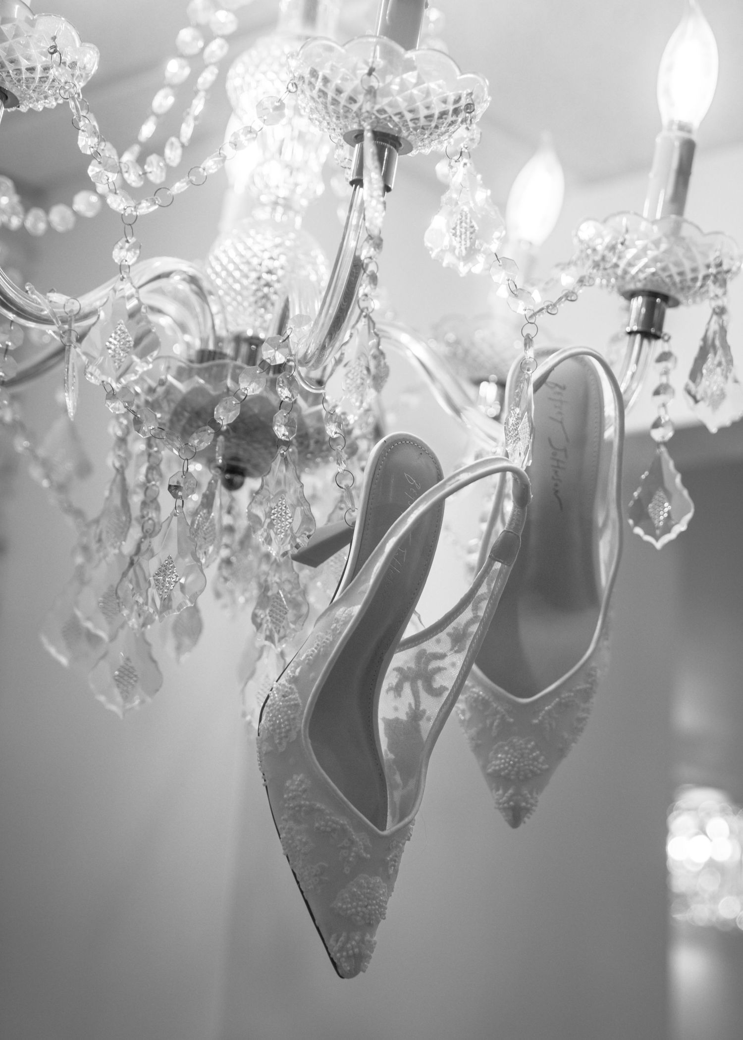 Crystal chandelier details shown in black and white with sparkling glass drops and ornate metalwork.