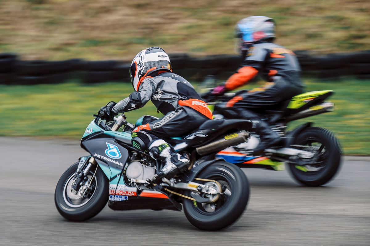 Multiple motorcycles racing with motion blur showing high-speed action on track.