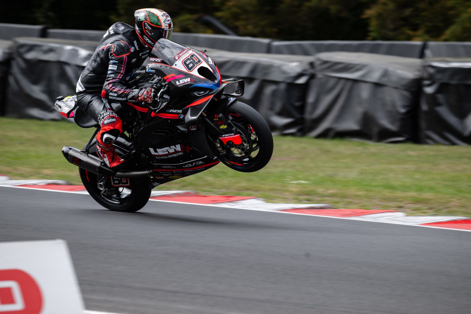 A motorcycle rider leans into a turn on a racing track during a high-speed competition.