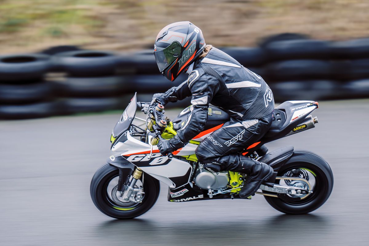 Sport bikes racing at high speed with dramatic motion blur on curved track section.