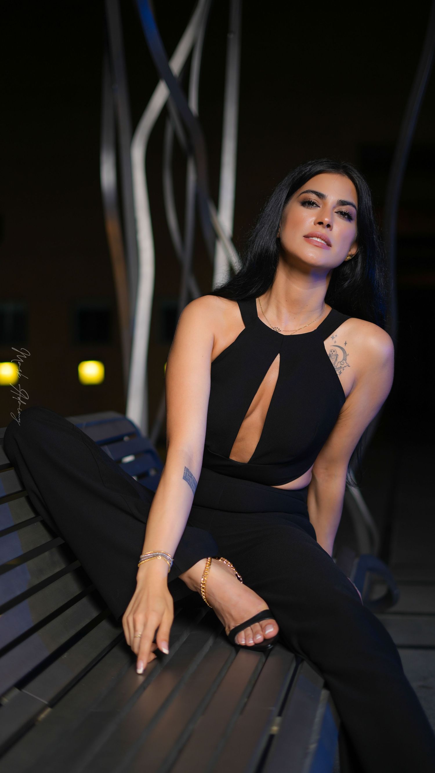 Lebanese young female model in black jumpsuit on bench in Downtown Beirut