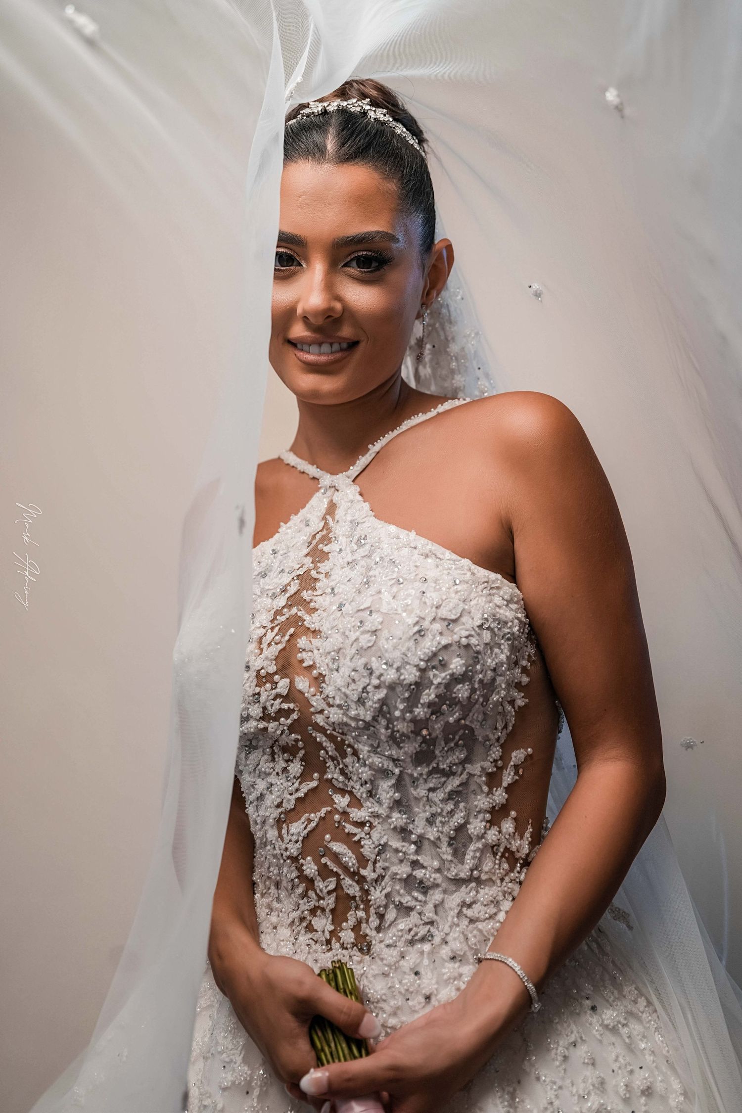 Gorgeous Lebanese bride taking a picture with her veil