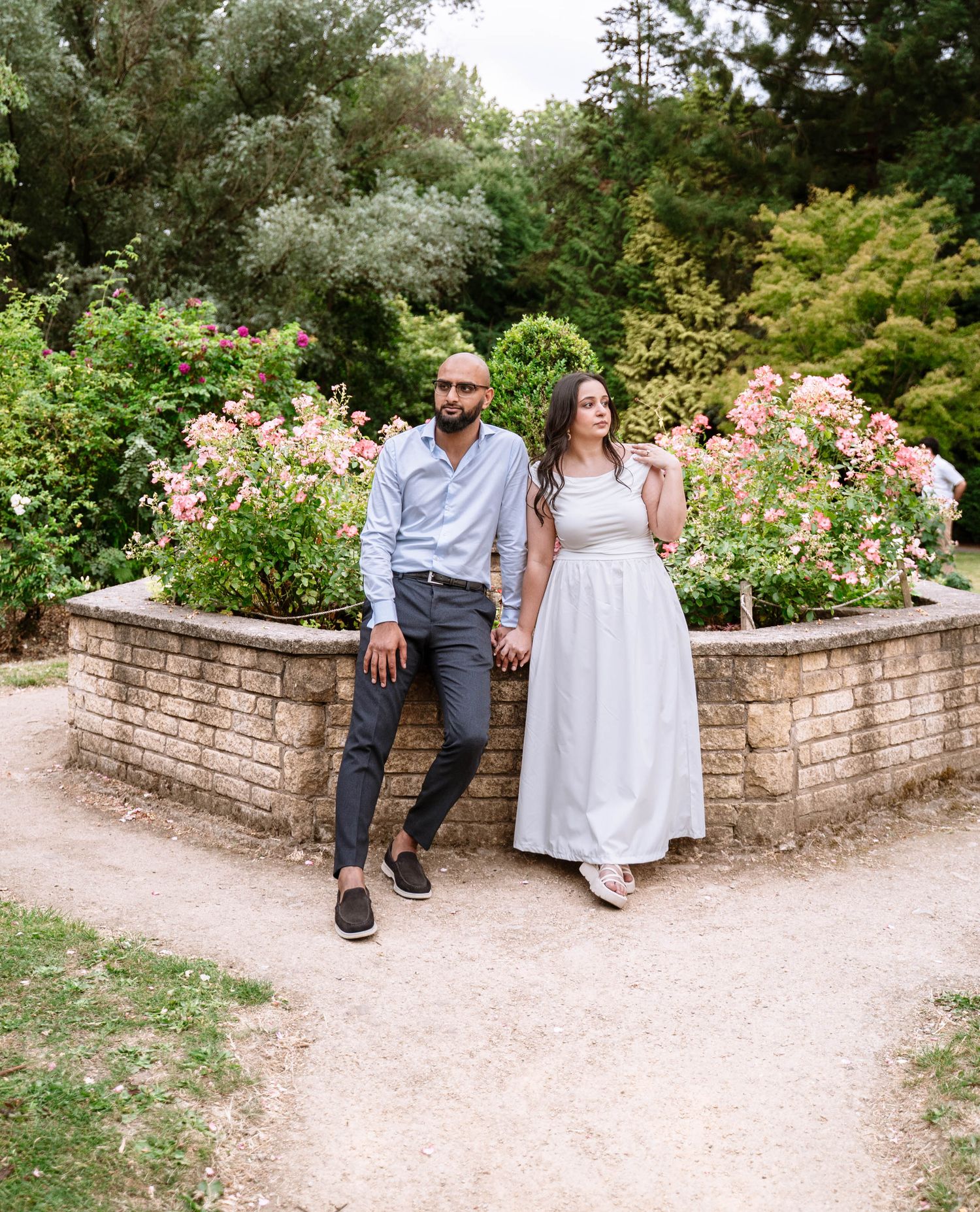 Couple sitting in front of the flower gardens at Fletcher Moss Park