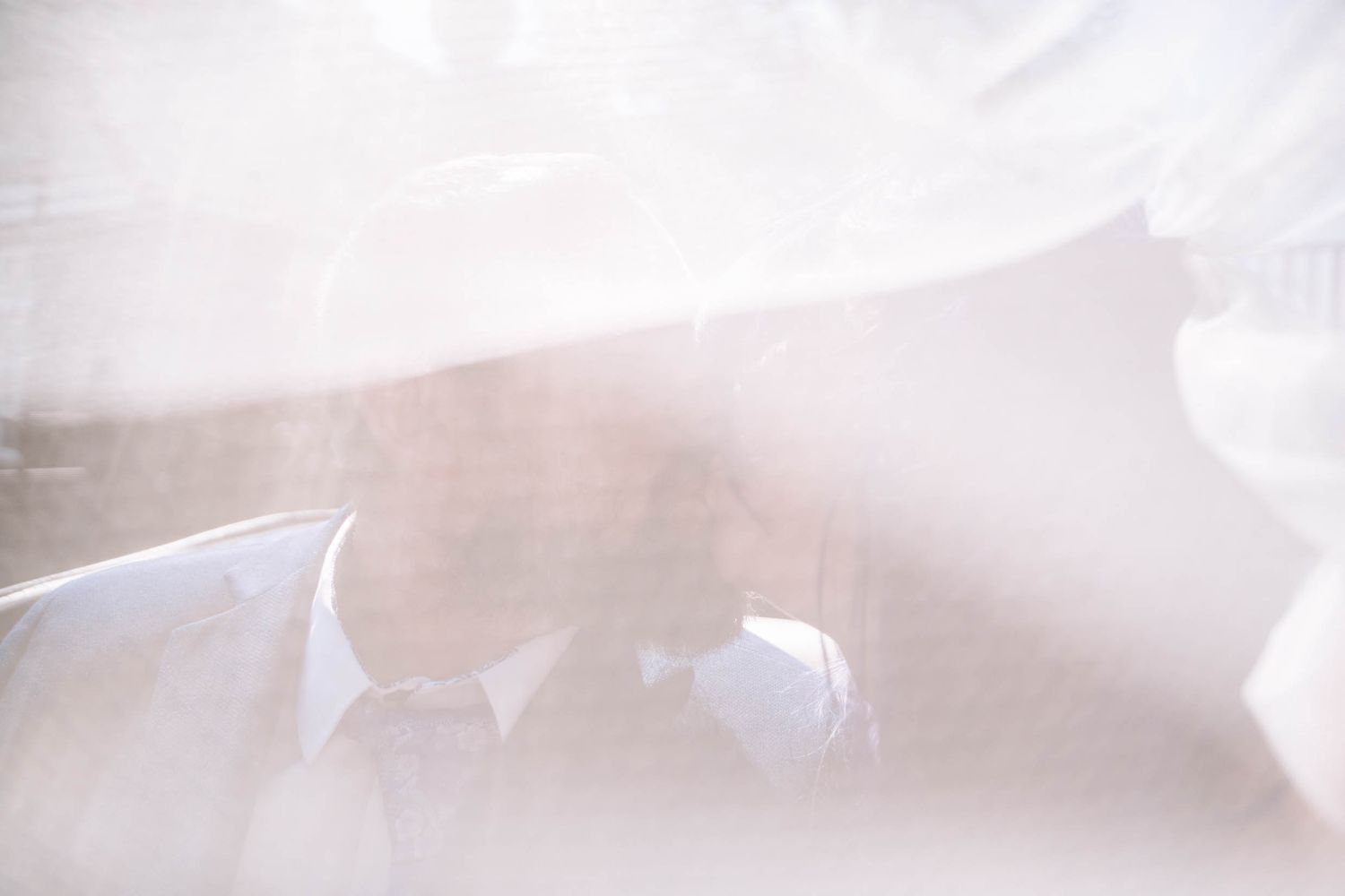 Couple embracing beneath a wedding veil during a Wigan registry office wedding