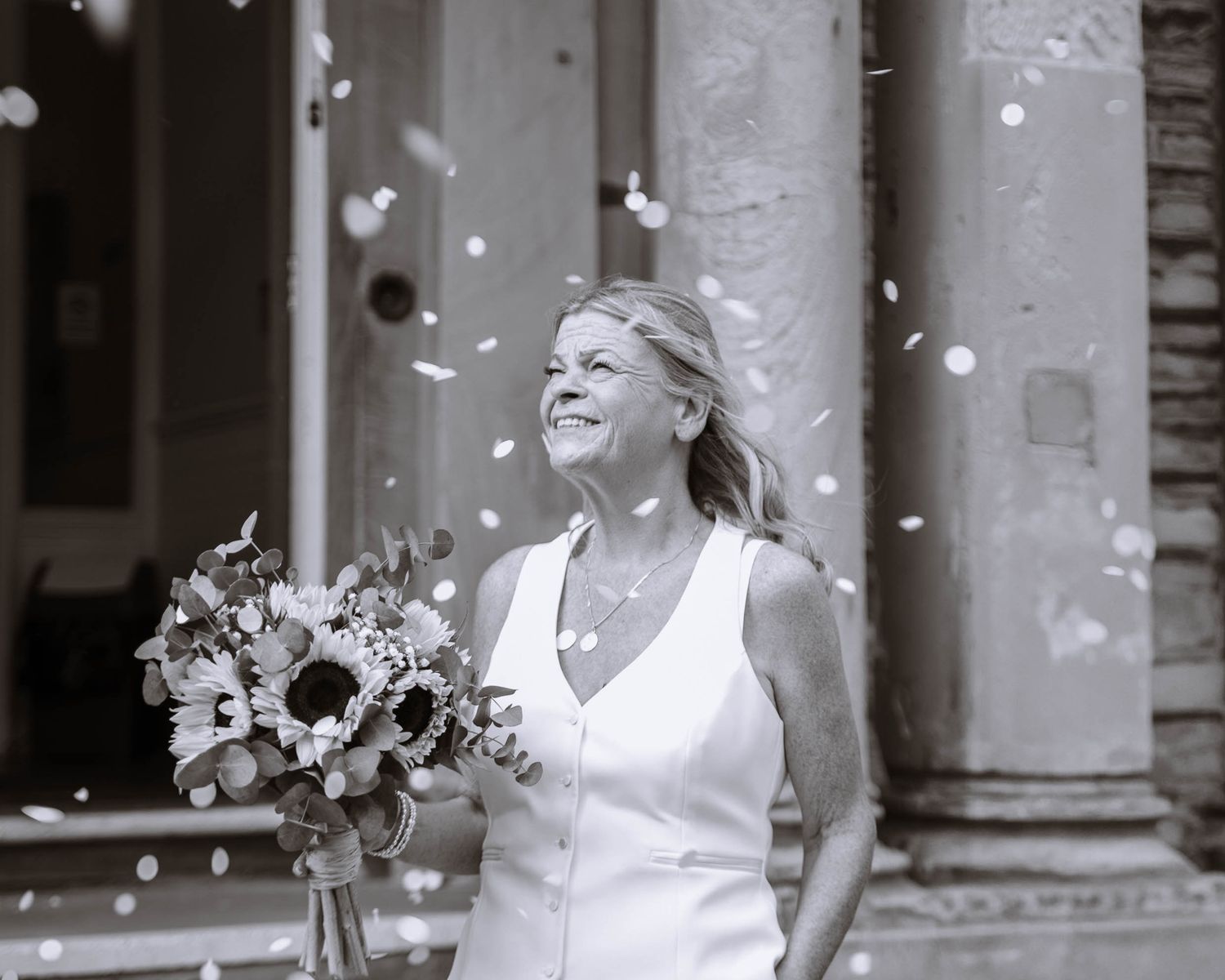 Bride leaving Waterloo Town Hall with her bouquet as confetti falls around her