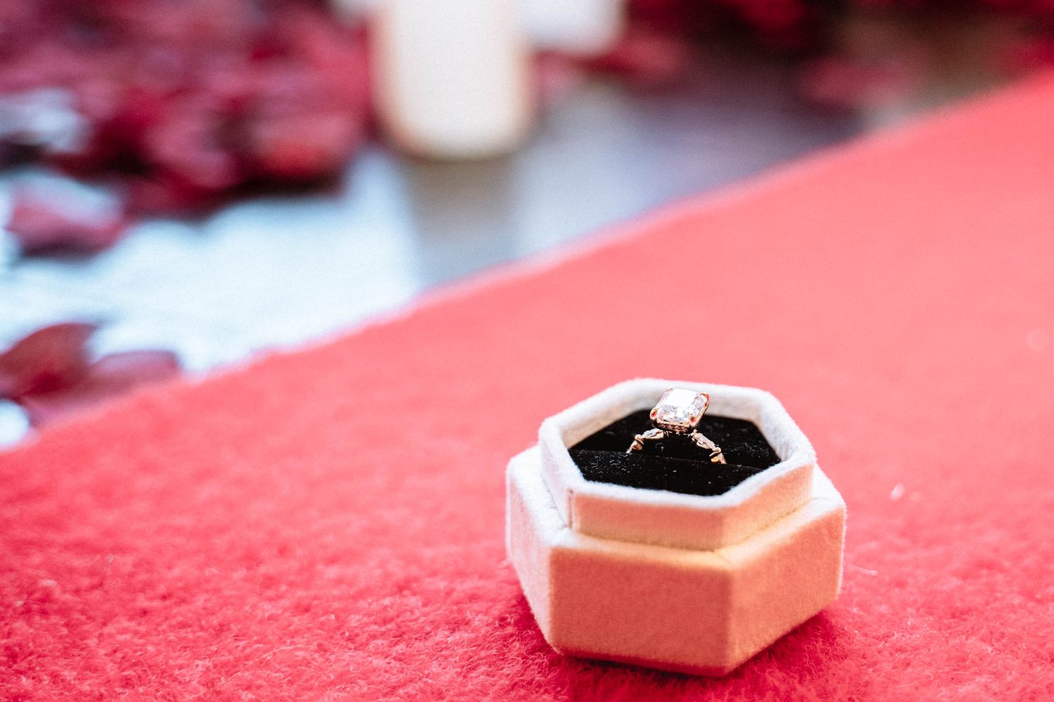 Engagement ring in box on red carpet during a proposal setup in Manchester