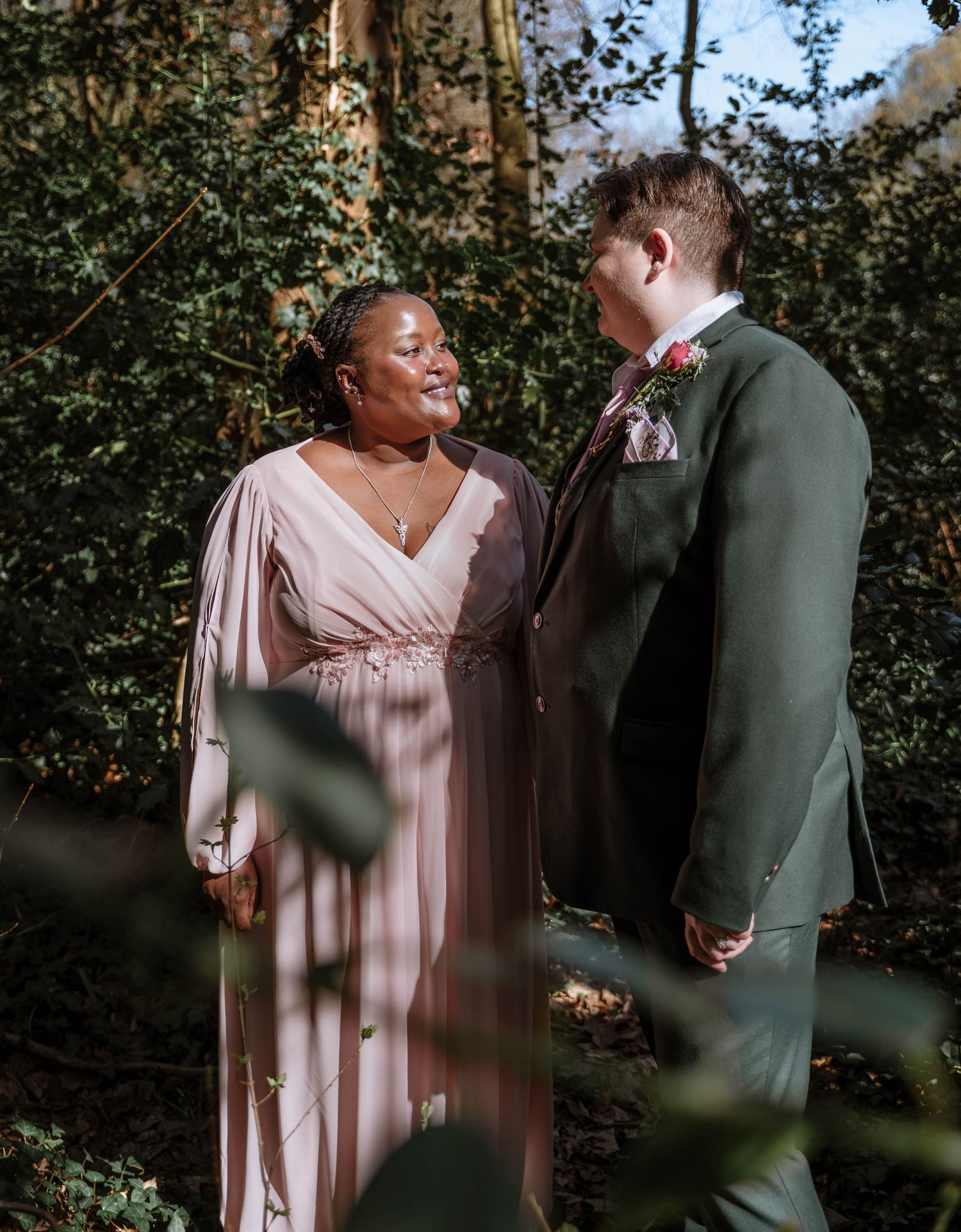 Couple standing together outdoors in greenery during Manchester LGBTQ wedding