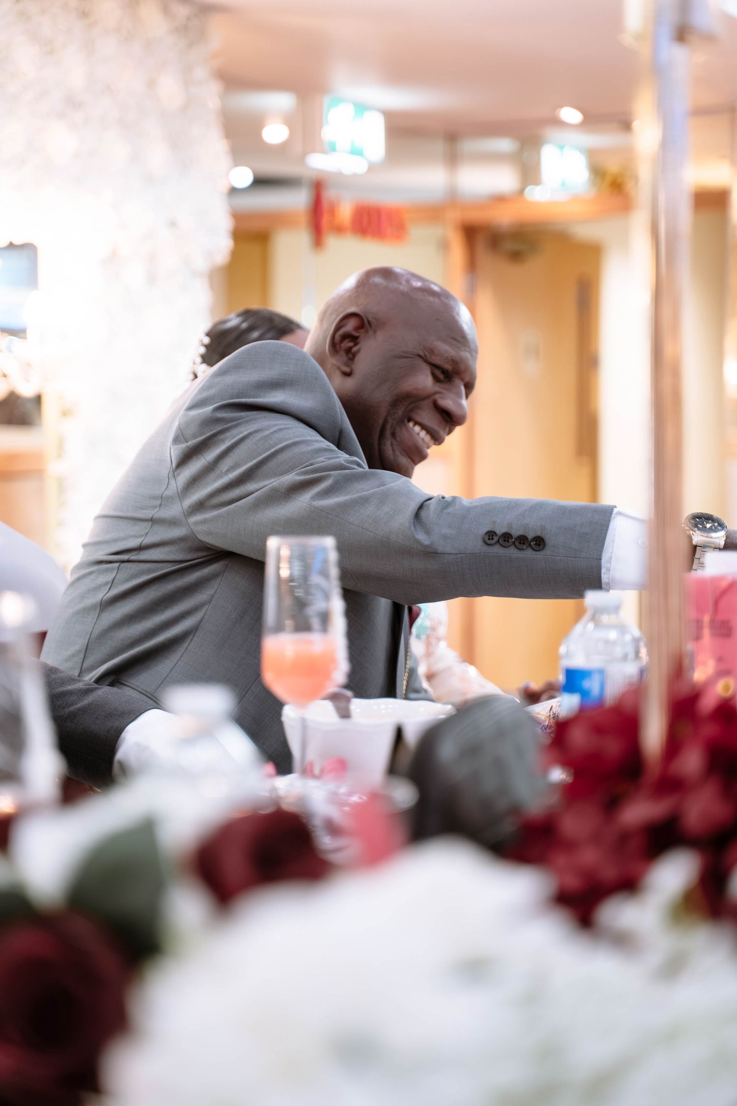 Dad laughing at table during Jamaican wedding reception in Birmingham