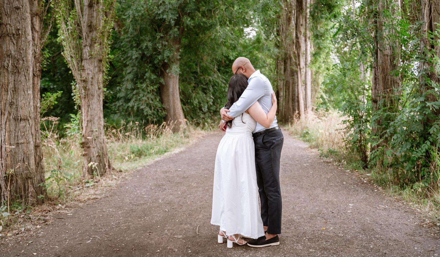 Couple embracing on a tree-lined path at Fletcher Moss Park, Manchester