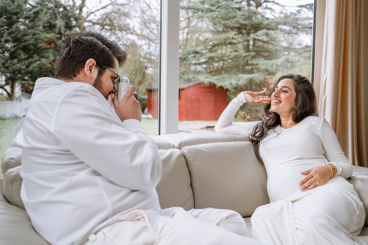 Pregnant woman relaxing on a sofa with her partner during an at-home maternity session in Manchester