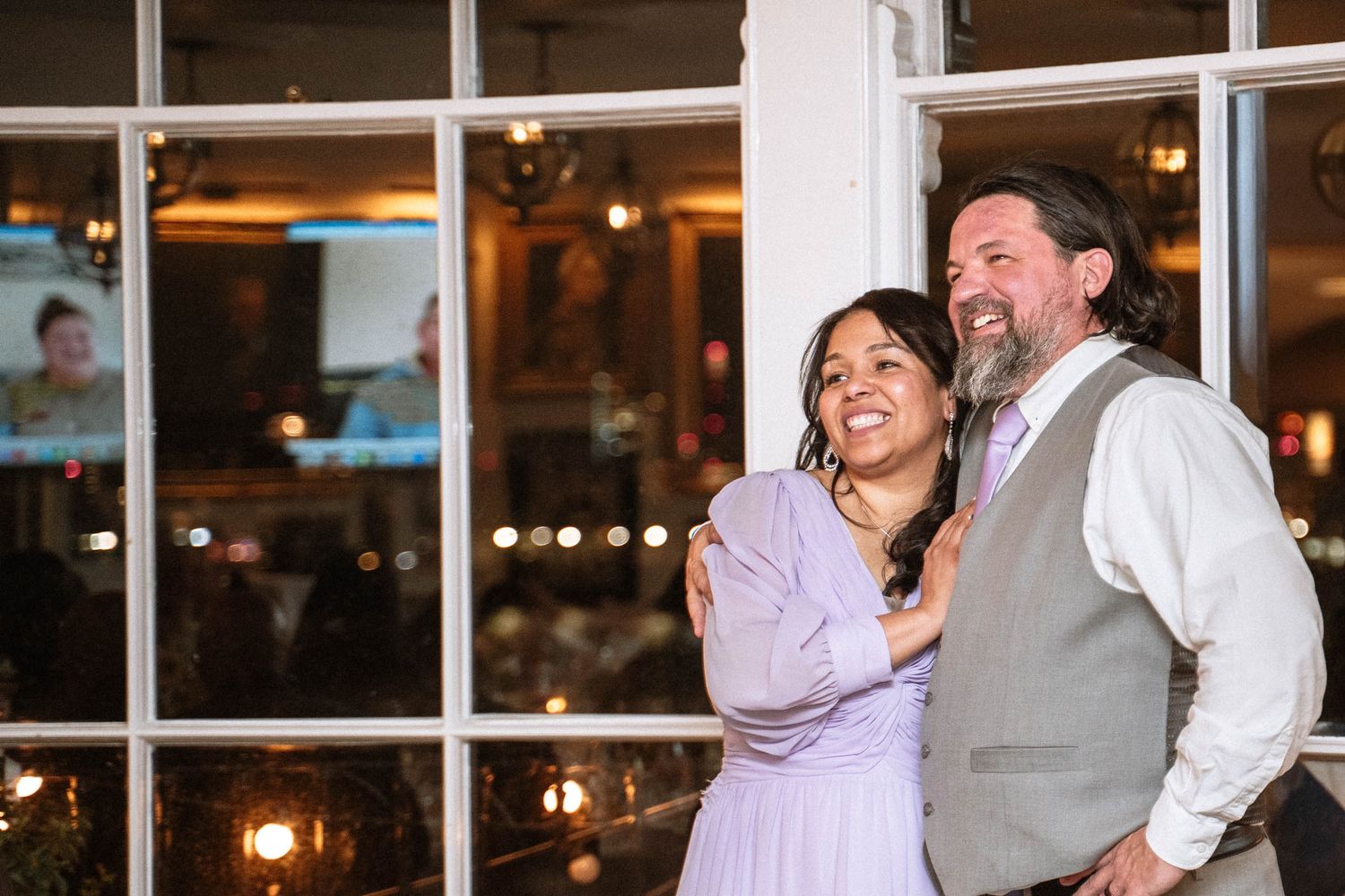 Bride and groom smiling together by window during Trafalgar Tavern wedding reception