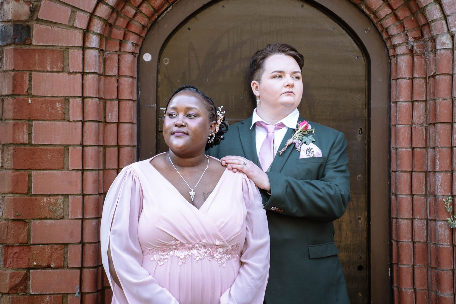 Couple posing under brick arch doorway during Manchester registry office wedding