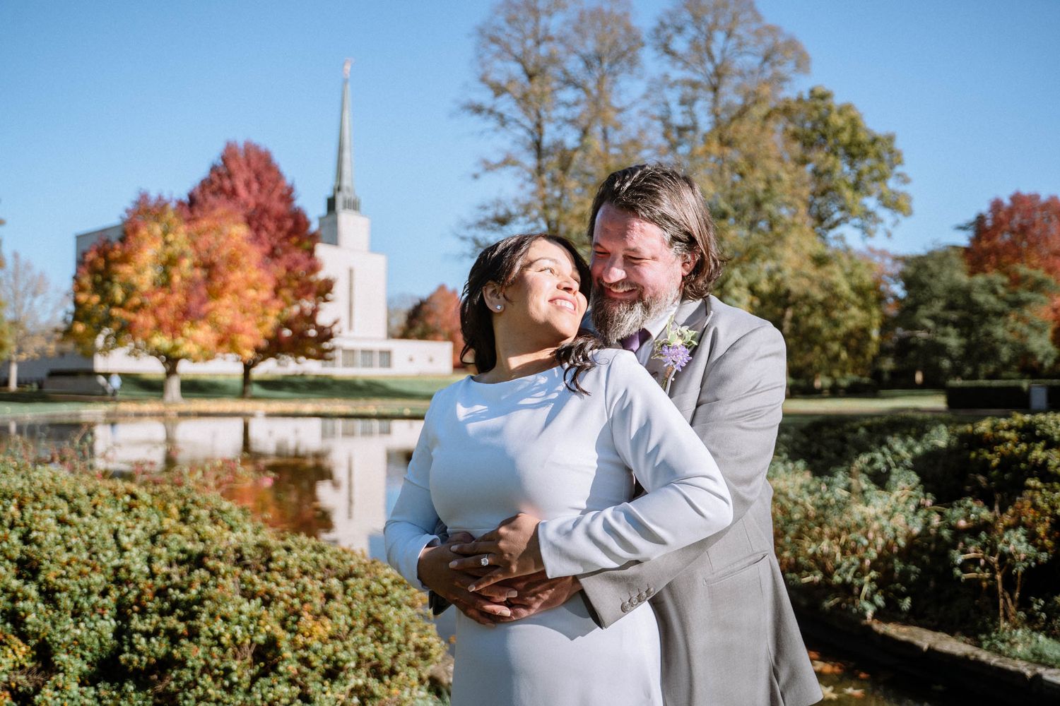 Couple embracing outdoors near LDS temple during wedding portraits in London