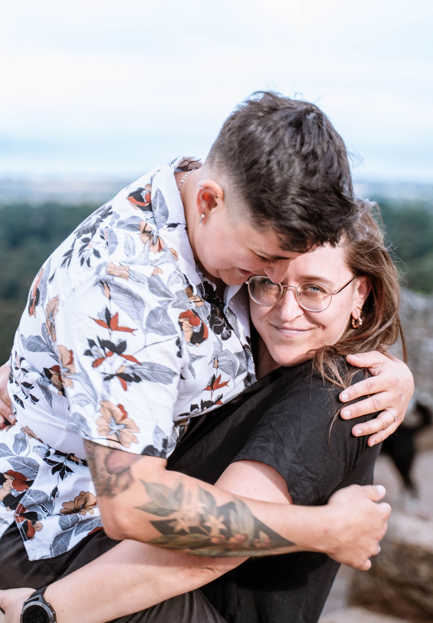 A lesbian couple hold one another closely during portraits after their proposal.