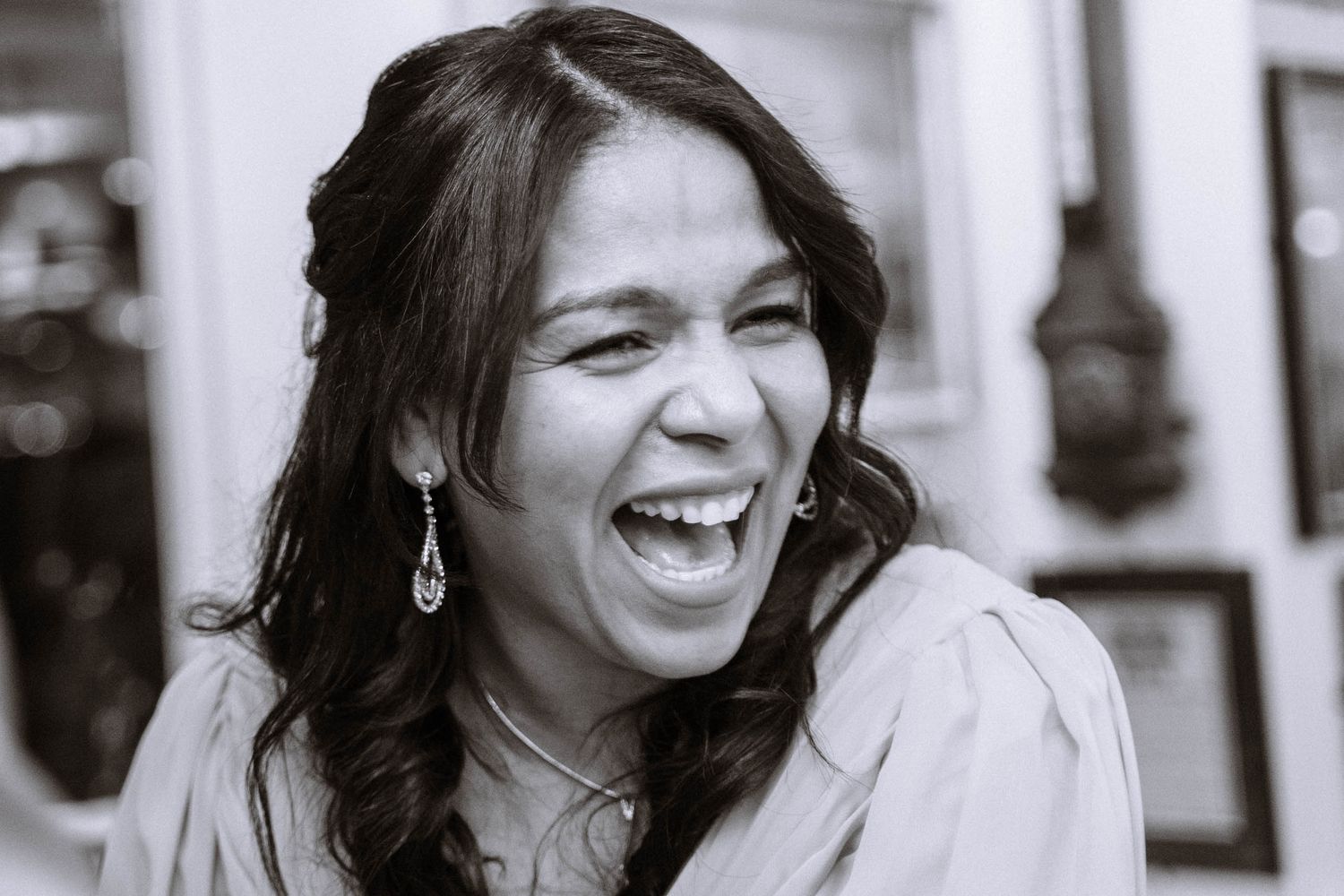 Bride laughing during wedding reception at Trafalgar Tavern in black and white