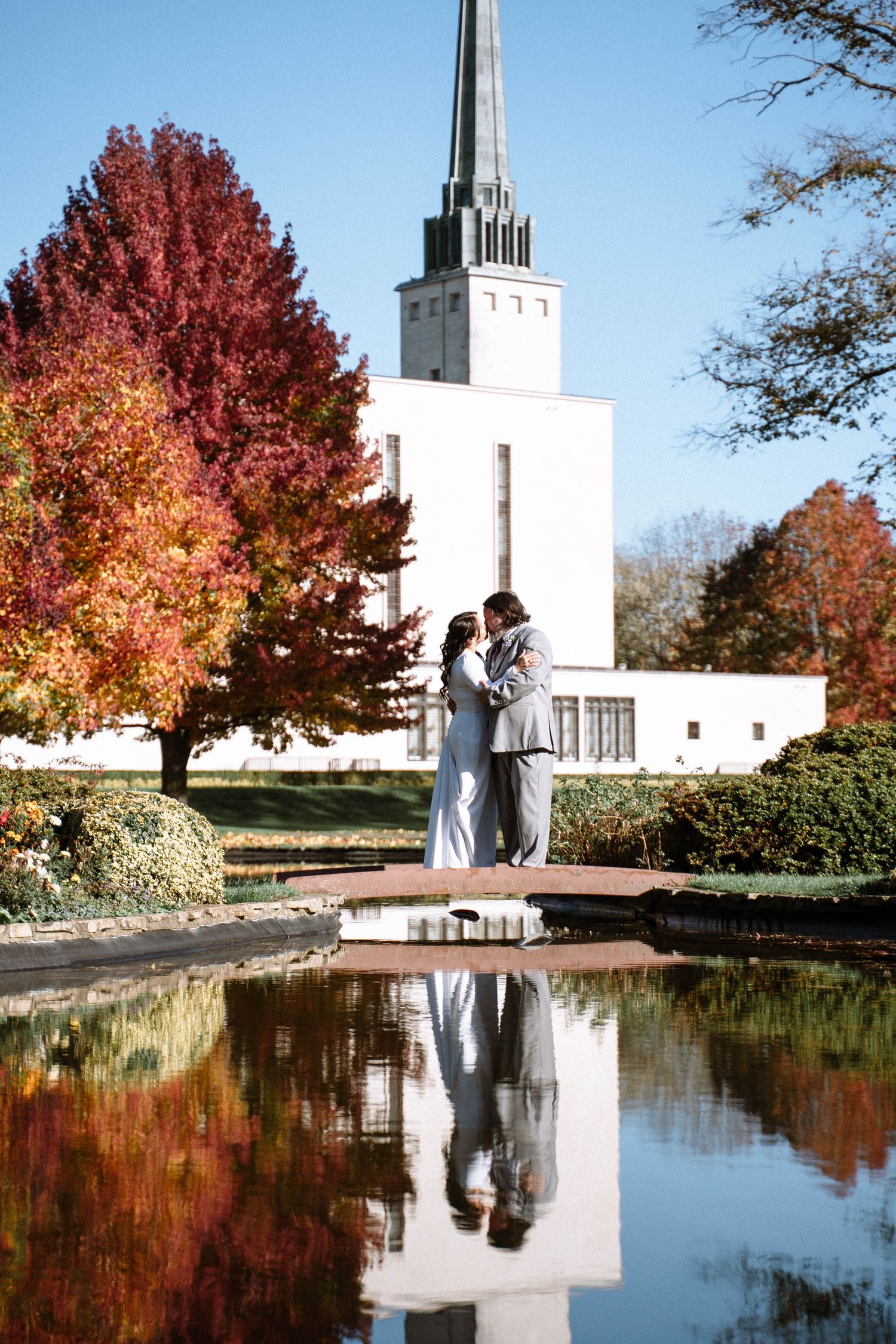 Couple reflected in water outside LDS temple during wedding photography