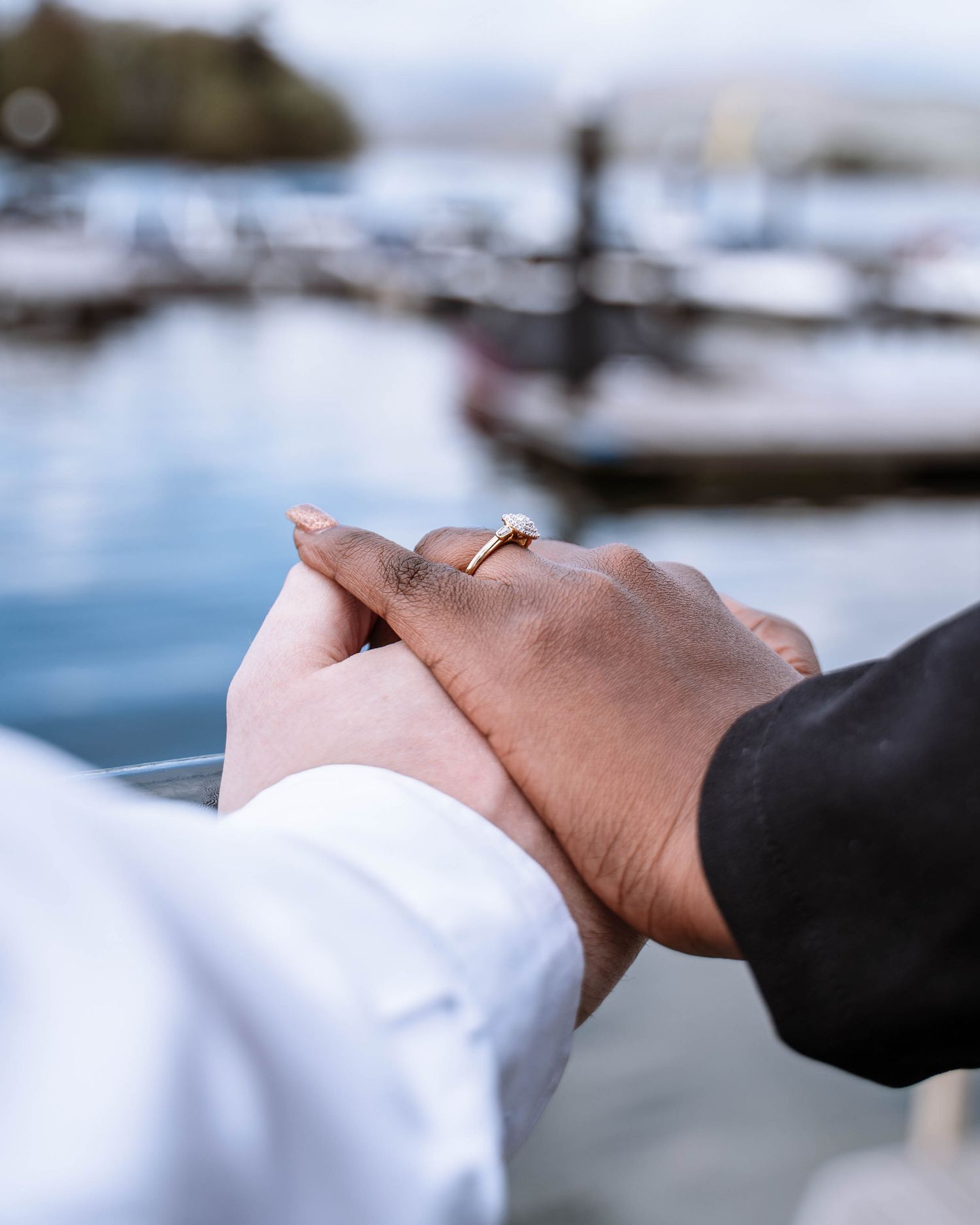 Couple holding hands in Windermere, Lake District after a proposal
