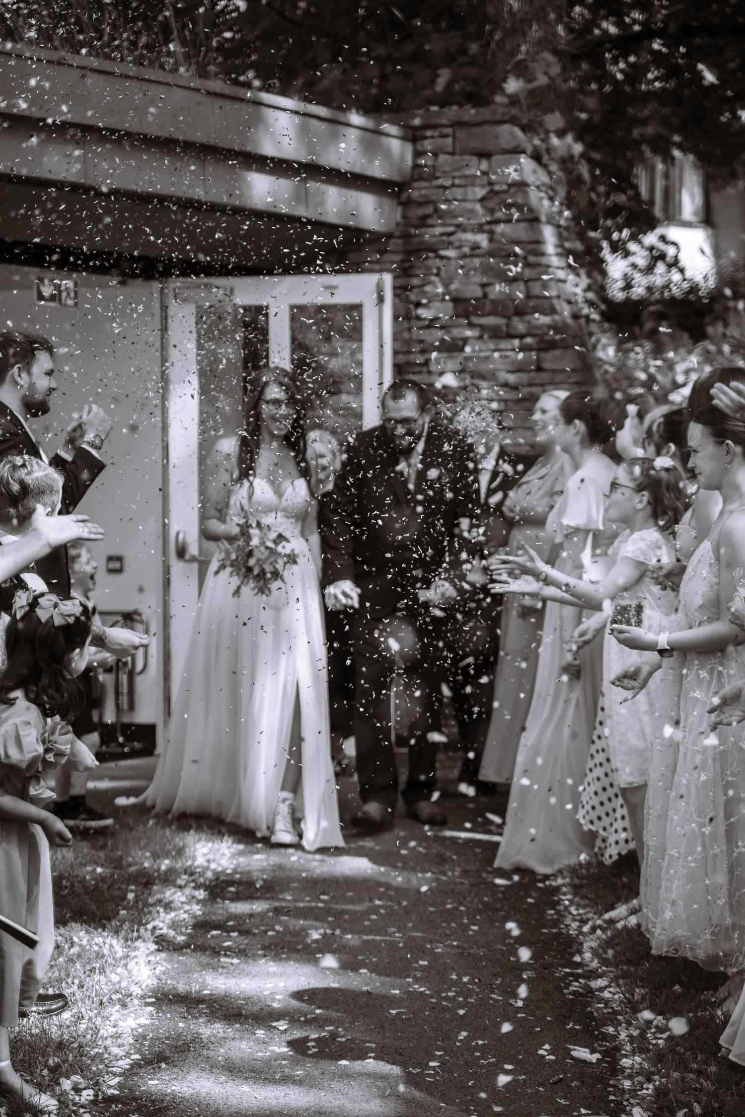 Bride and Groom exiting their registry wedding at the lodge, mesnes park and being surrounded by confetti