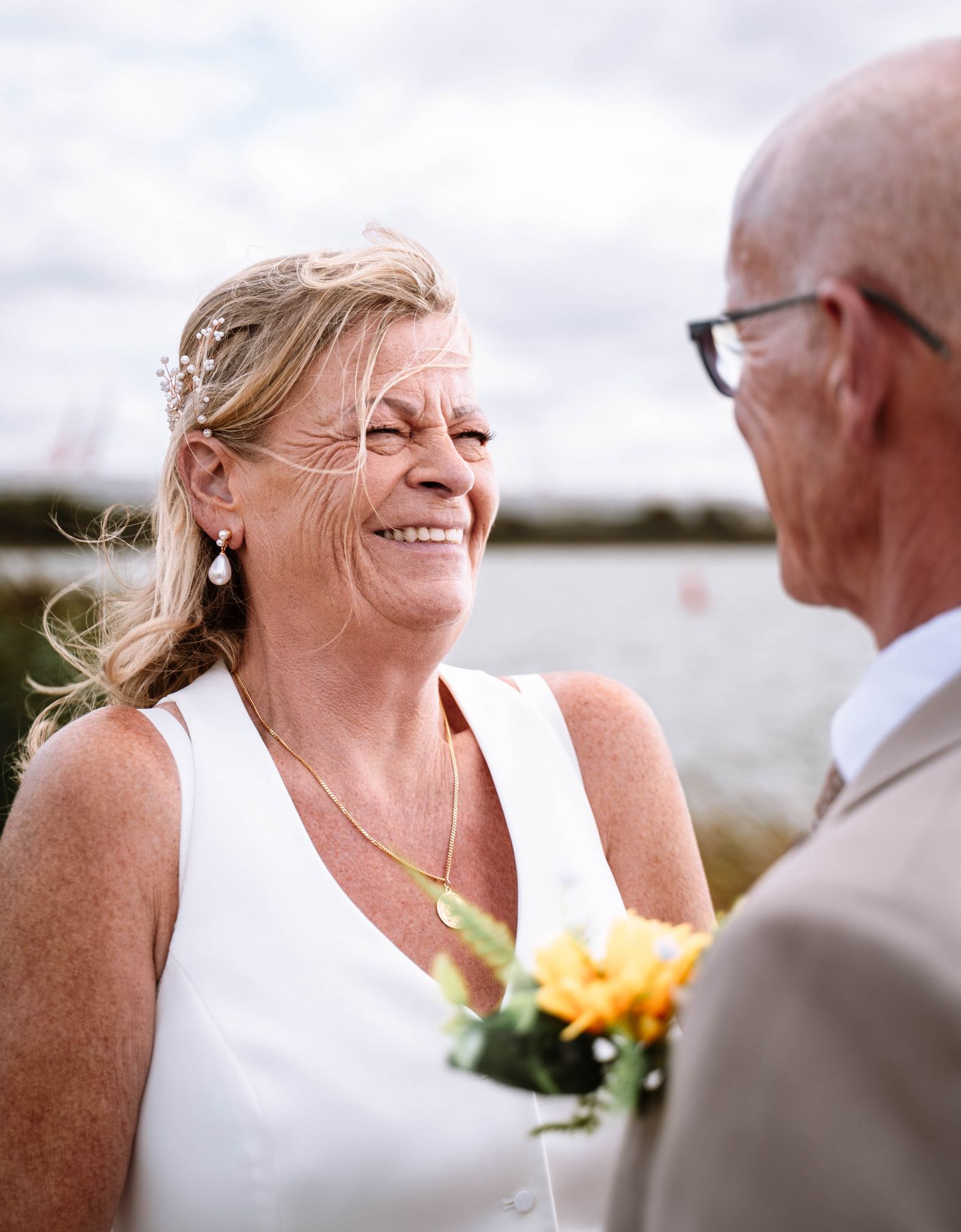 Bride smiling at groom while holding a bouquet near Crosby Marine Lake after their Waterloo Town Hall wedding