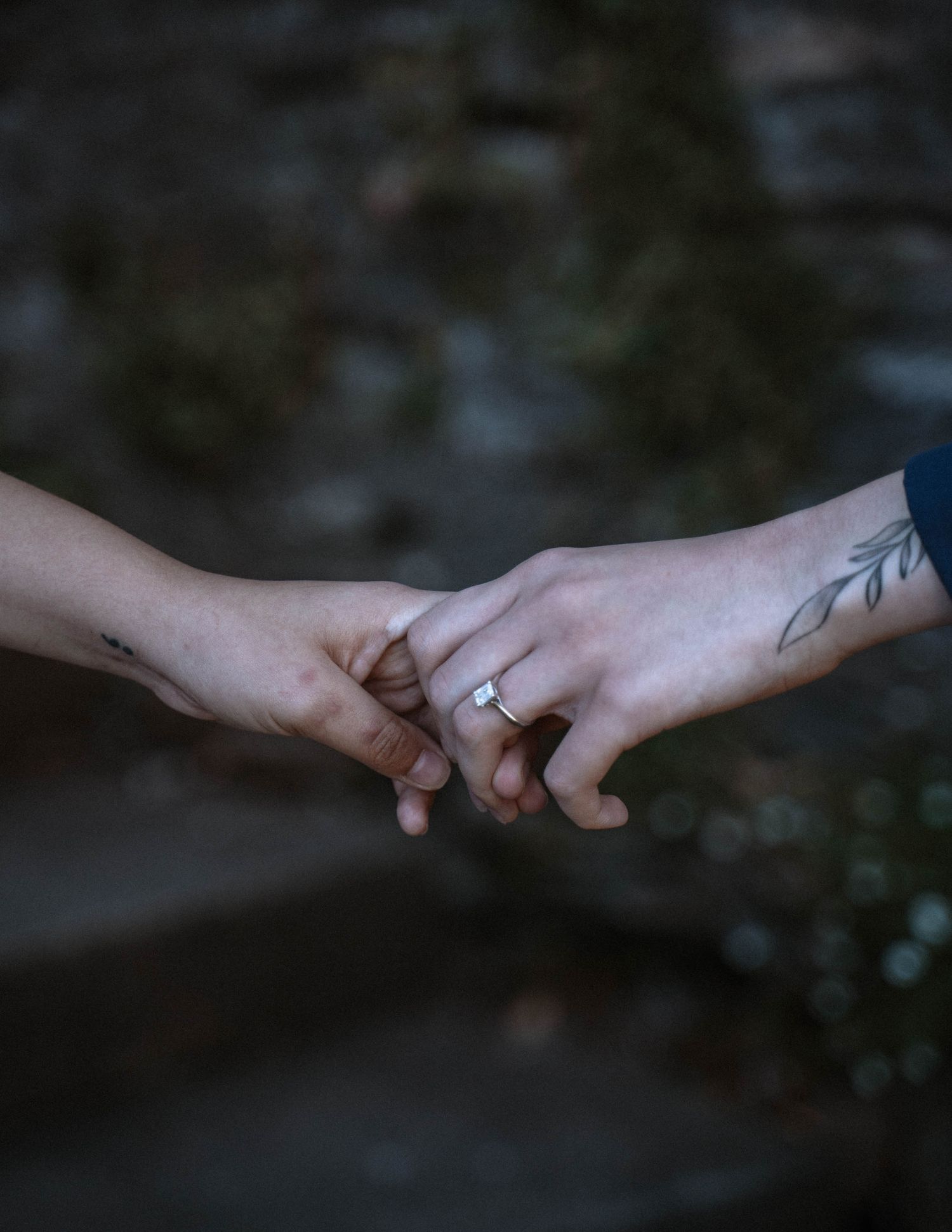 Close-up of Carolina and Mia holding hands during their queer proposal at Dyffryn Gardens