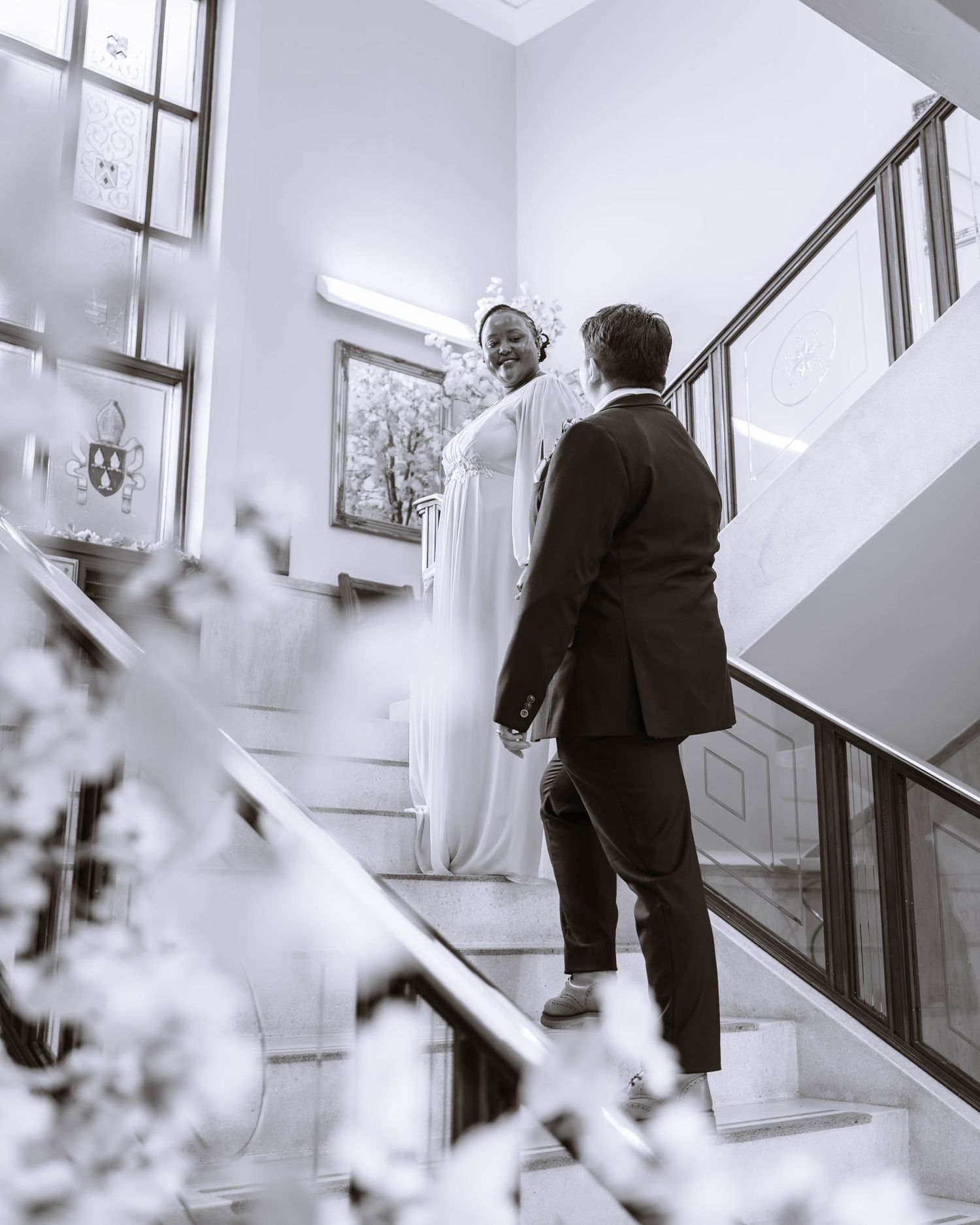 Black and white moment of couple walking together inside registry venue
